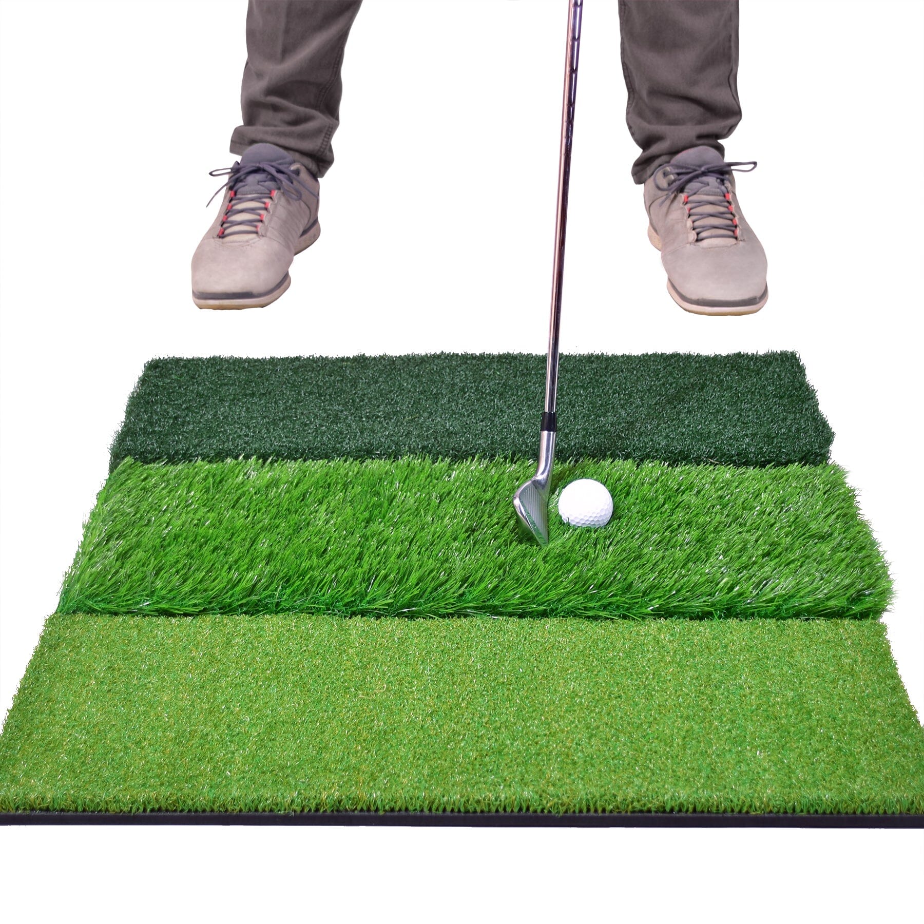 a man putting a golf ball on a green mat