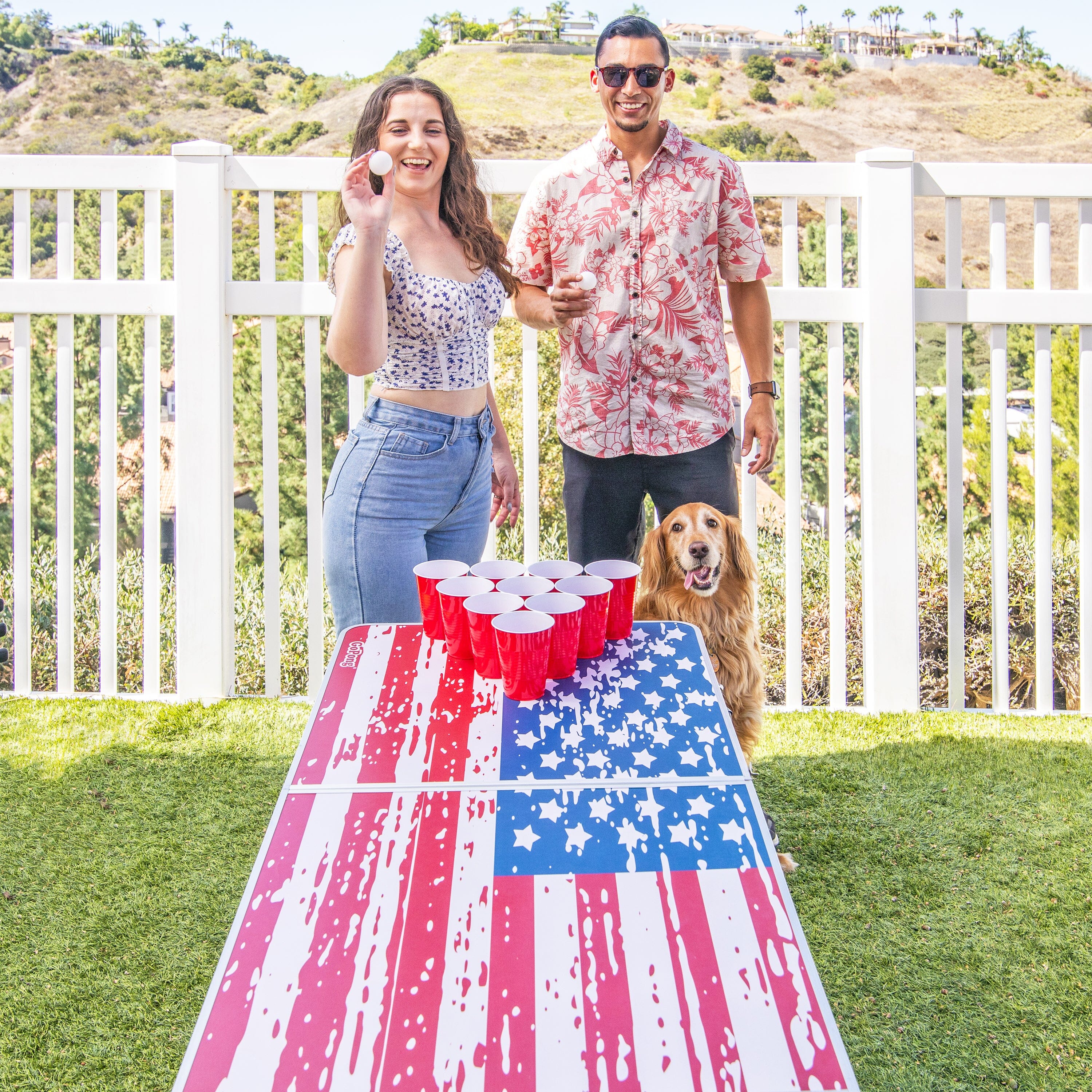 a man and woman standing next to a table with a dog