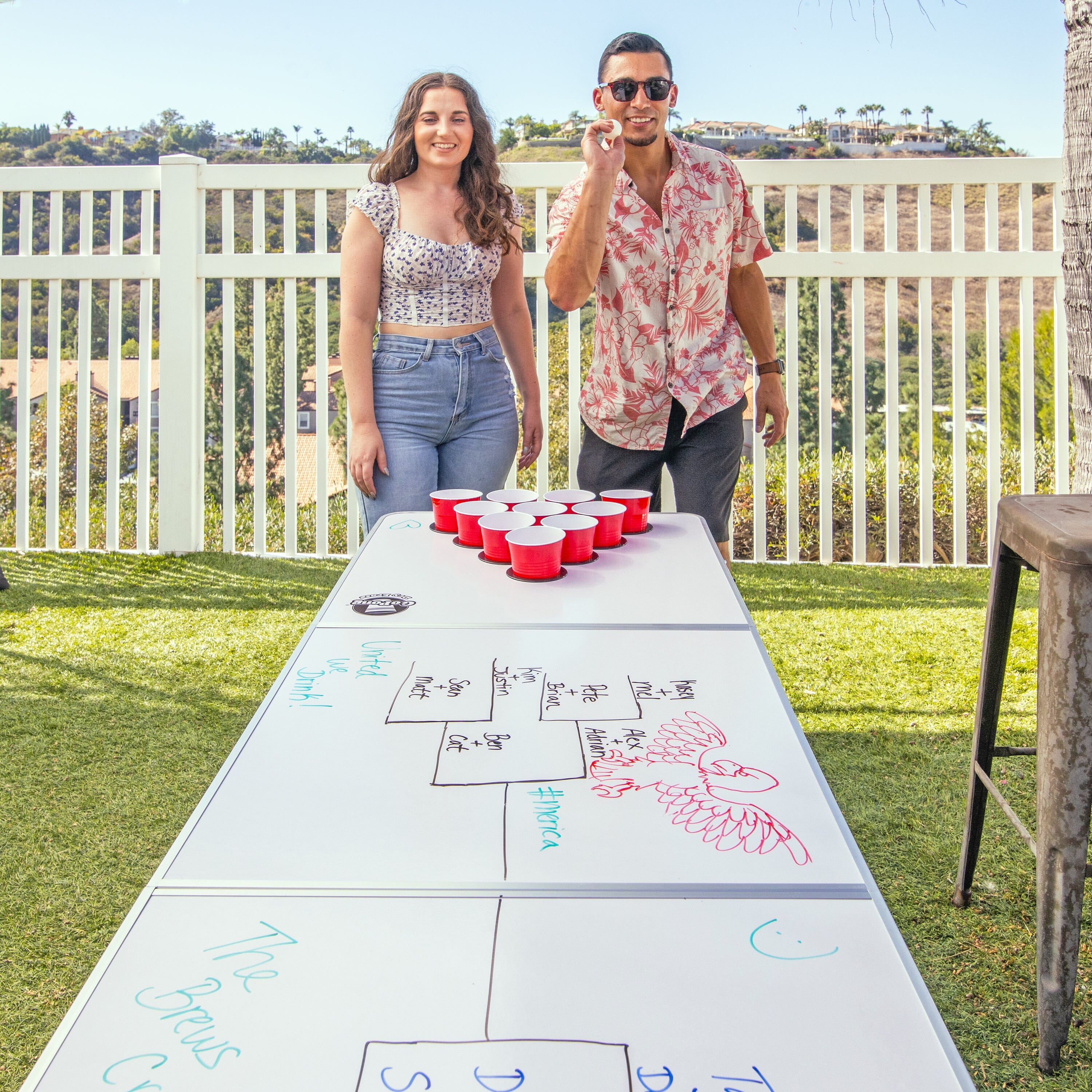 a man and woman standing next to a table with a game on it