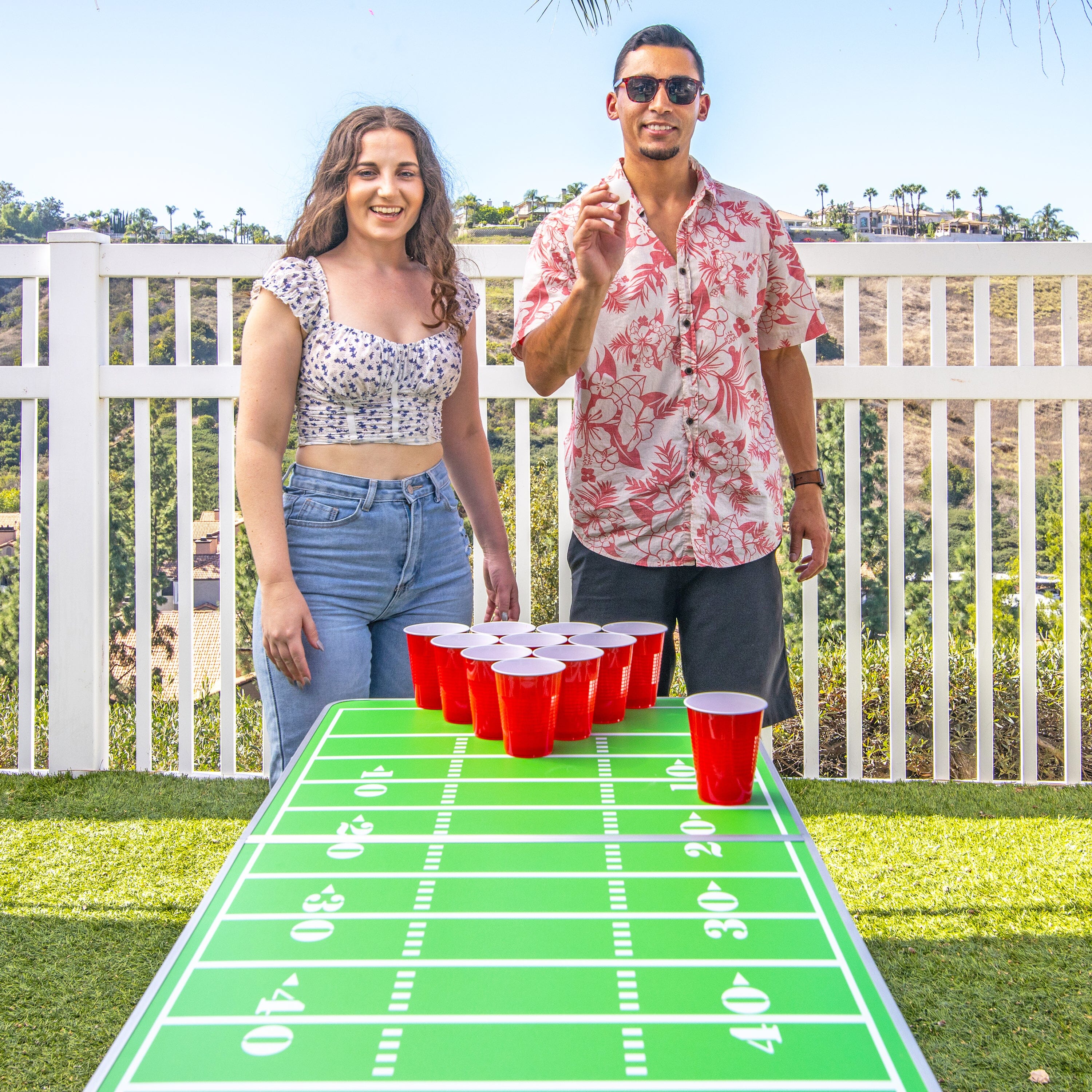 a man and woman standing next to a football field