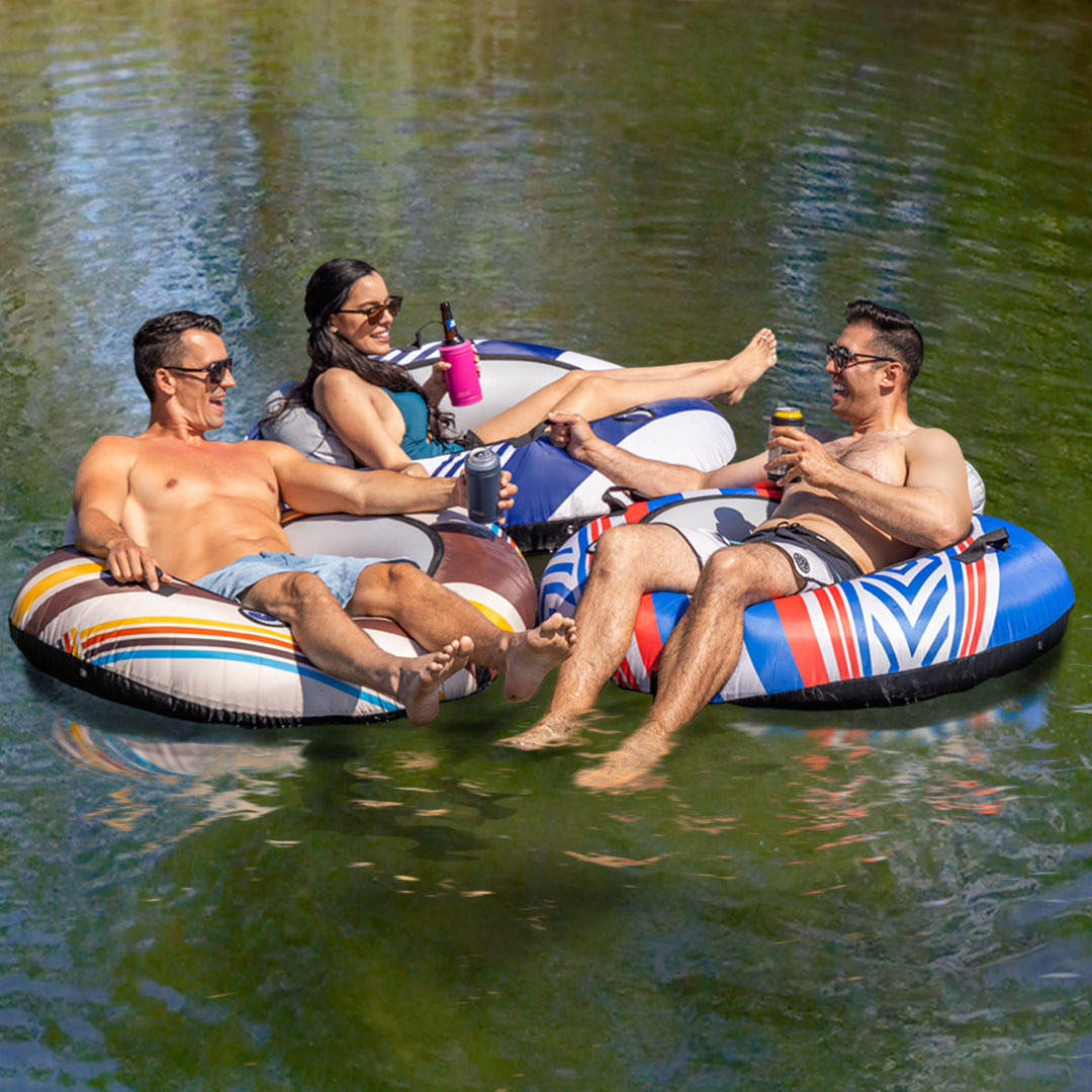Three people on inflatable tubes in a body of water, enjoying drinks.