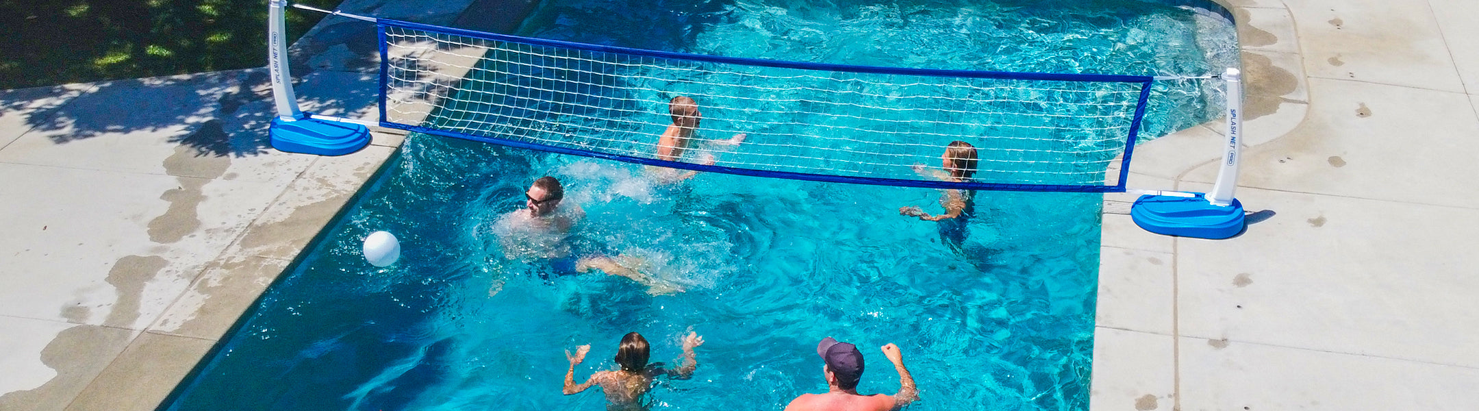 People playing water volleyball in a pool with a net.