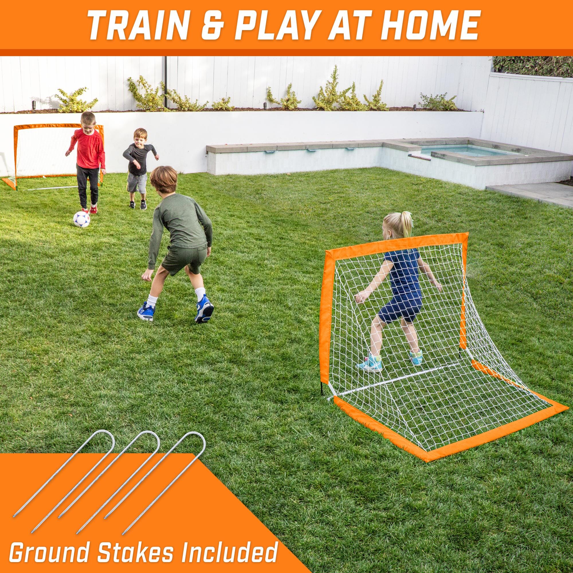 a kid playing soccer in the backyard with a ball and net