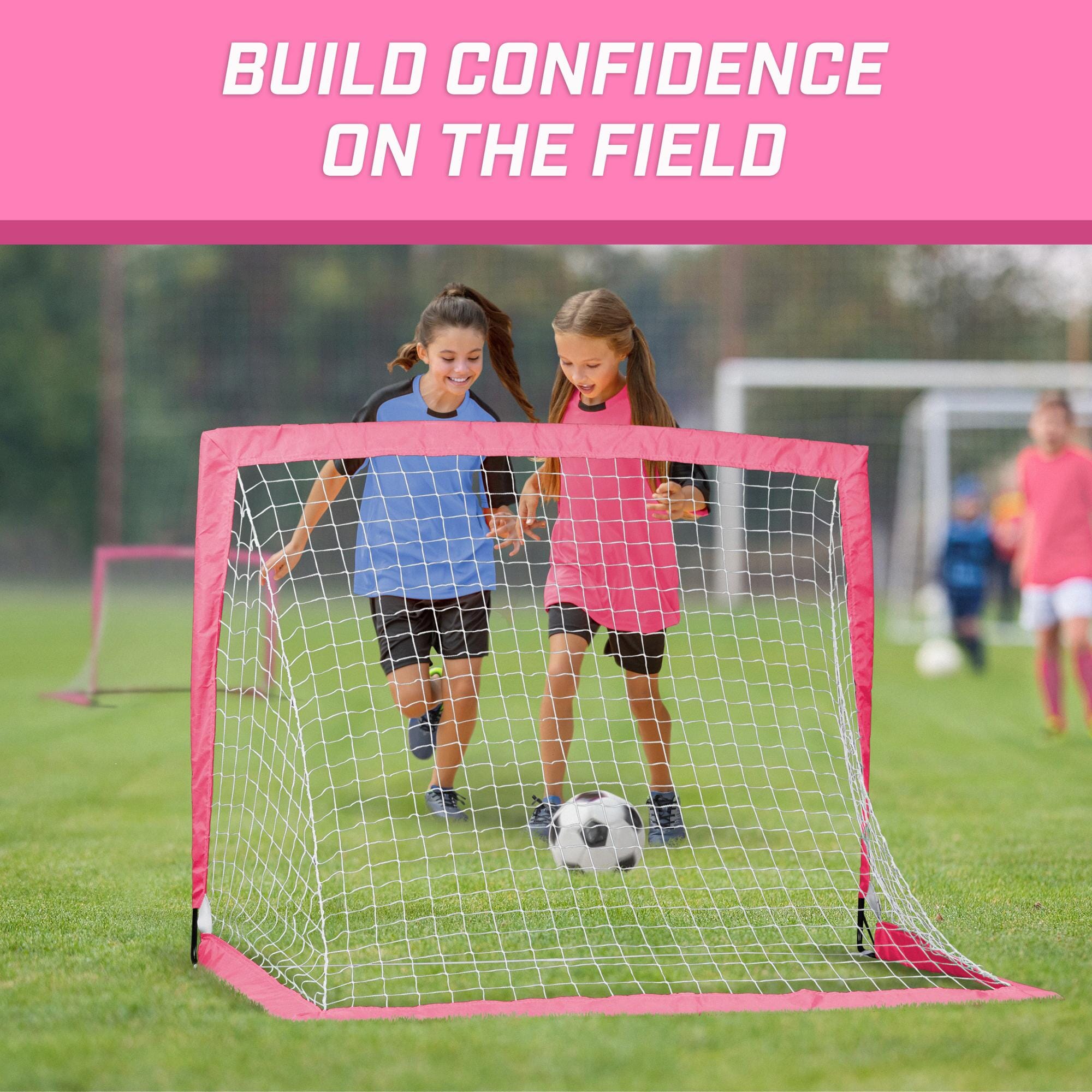 two children playing soccer in a pink soccer goal