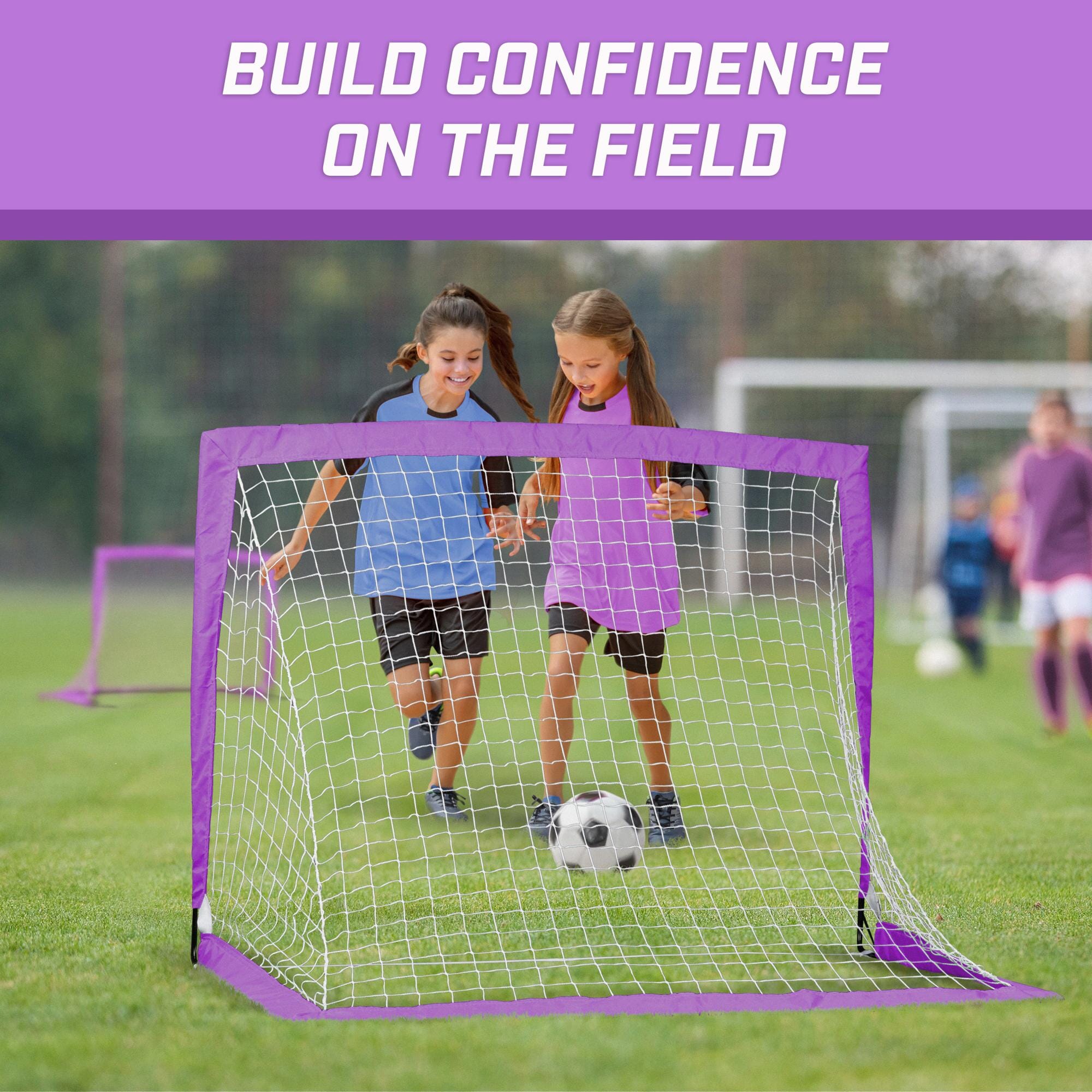a girl and boy playing soccer in a soccer goal