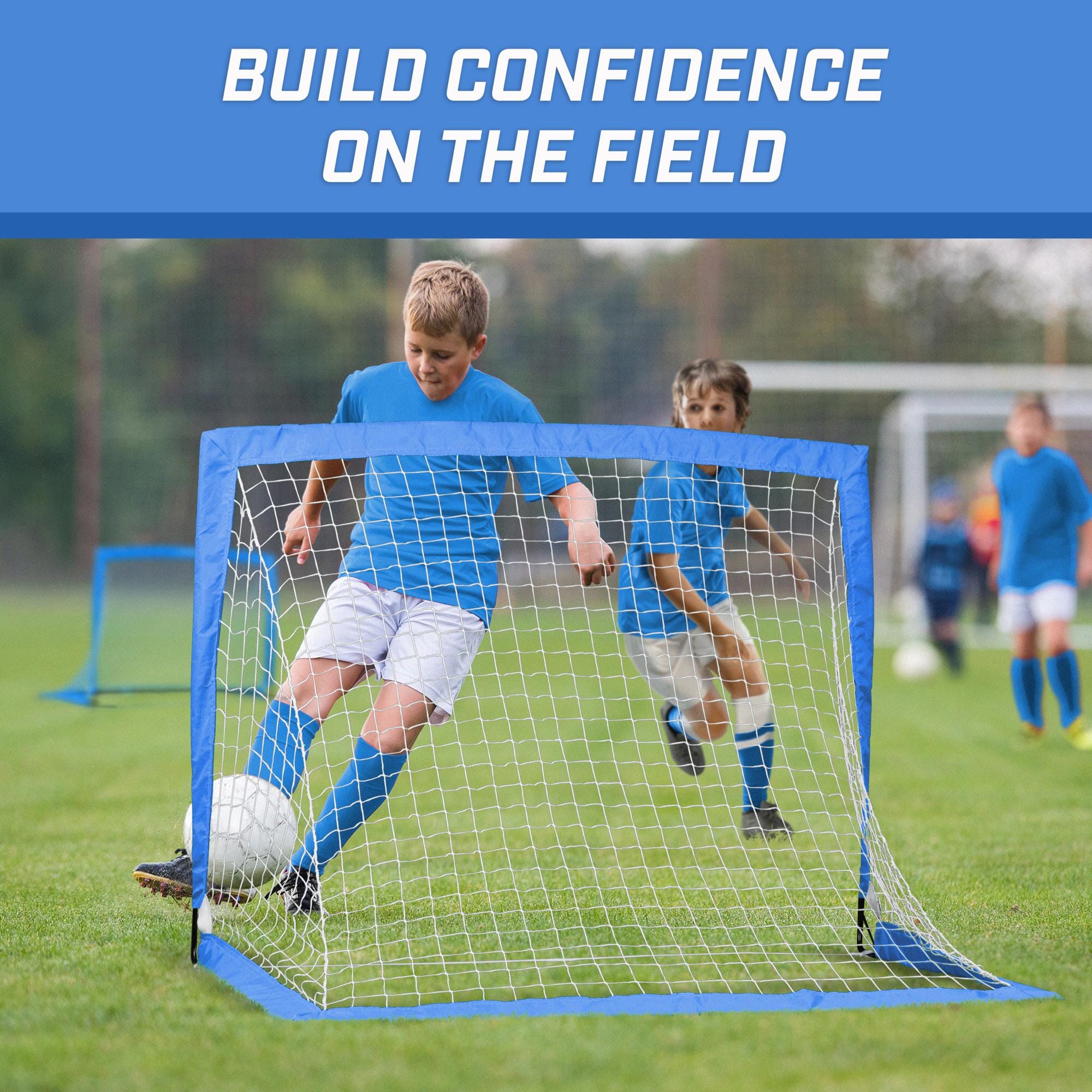 a young boy kicking a soccer ball in a goal