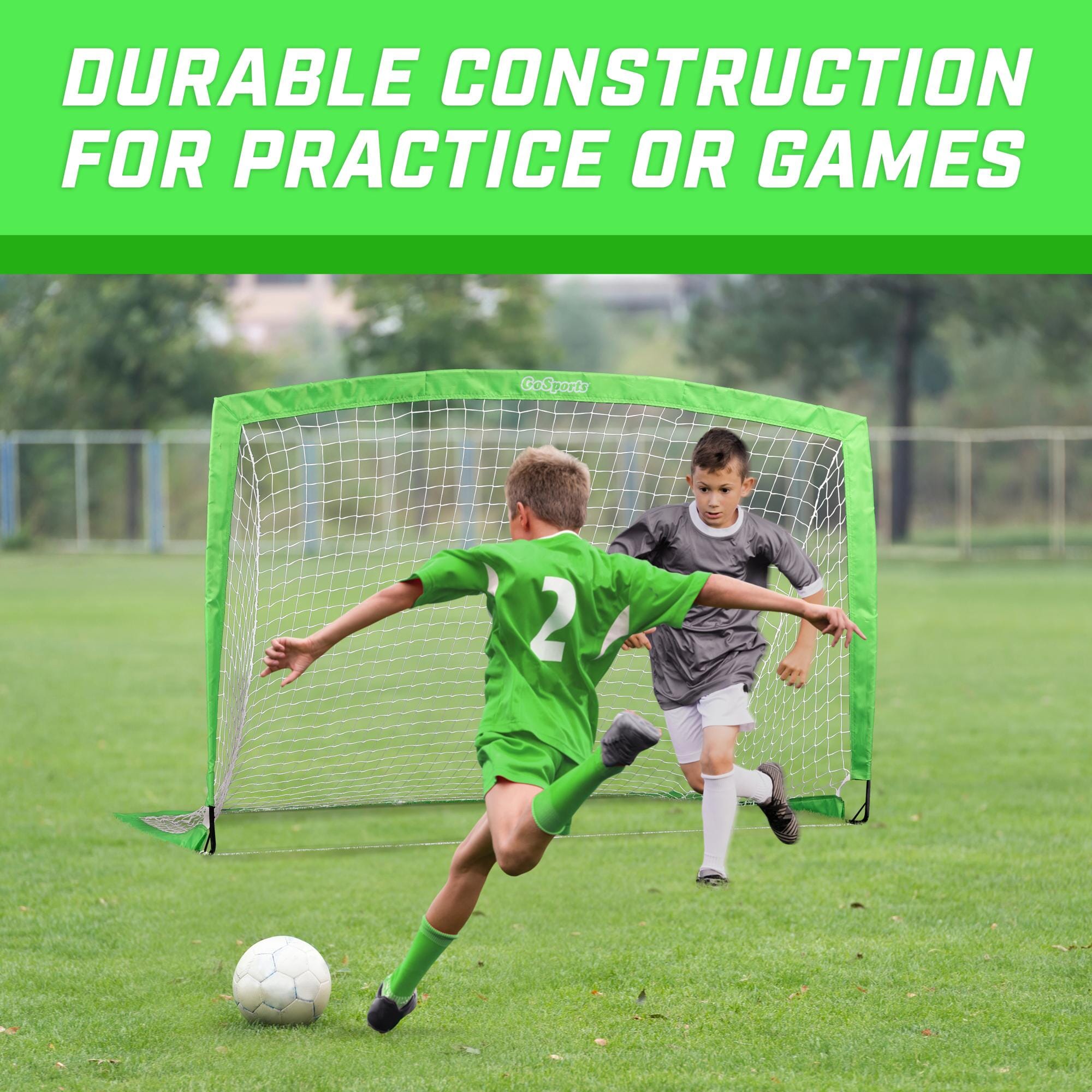 a young boy kicking a soccer ball in a field