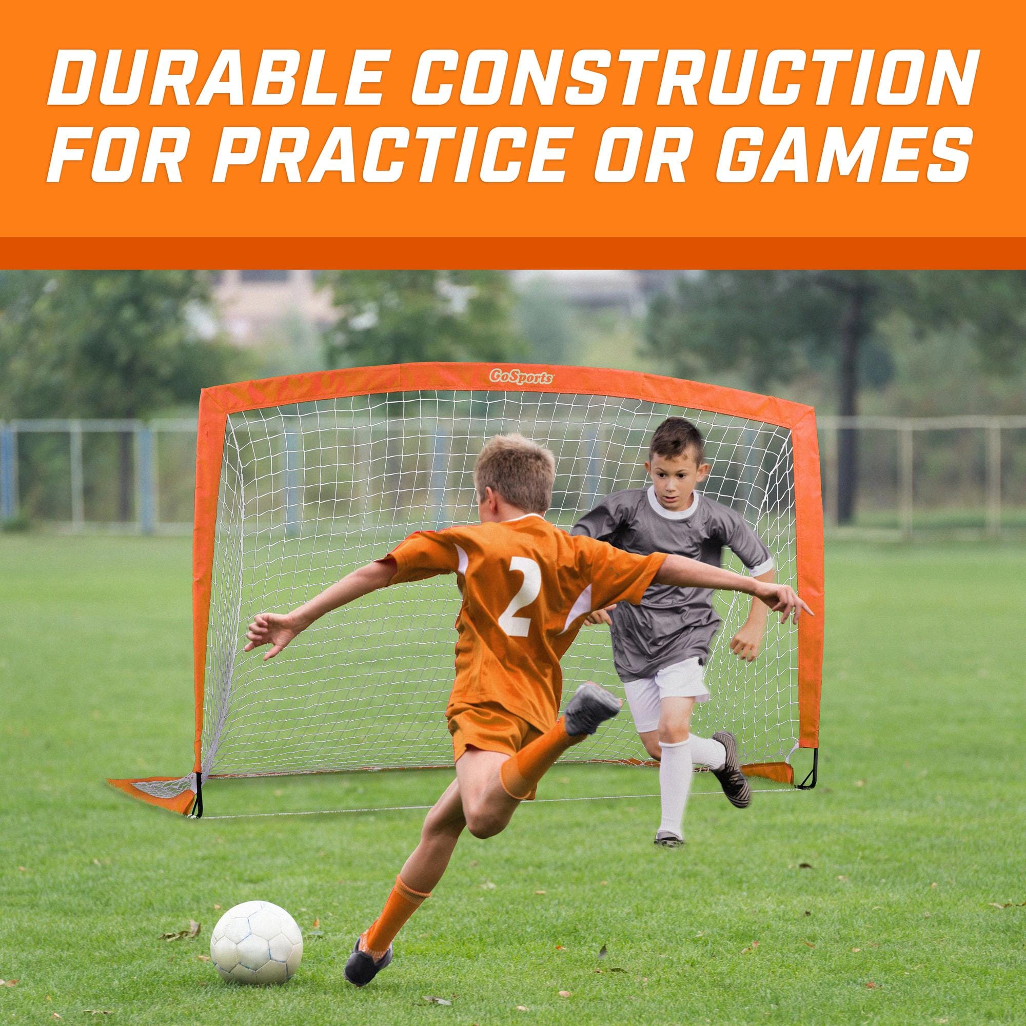 a young boy kicking a soccer ball in a field