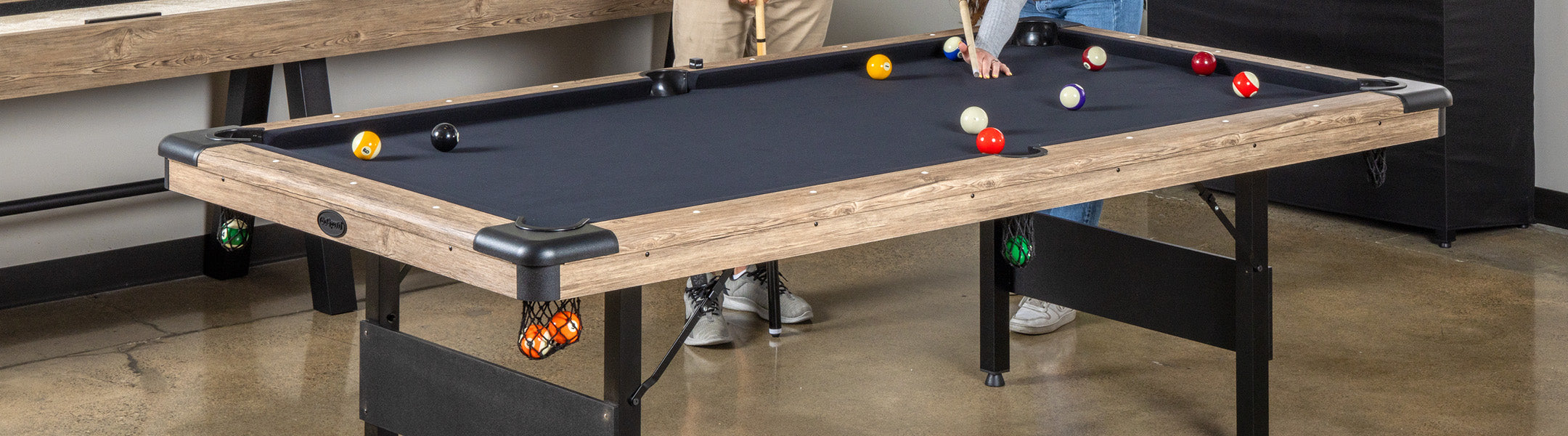 Pool table with billiard balls and cues in a casual setting