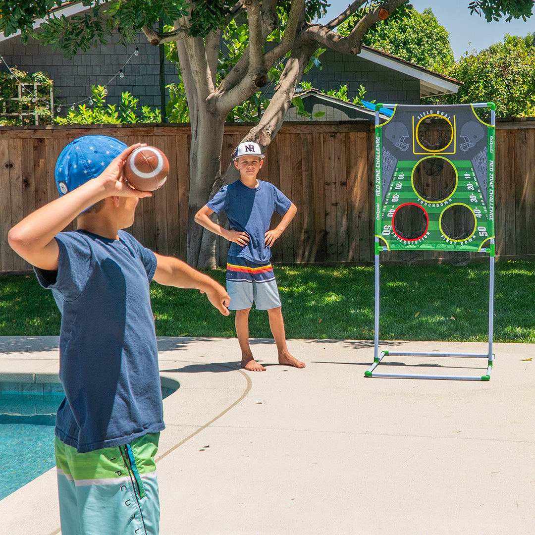 Two boys playing a game with a target in a backyard