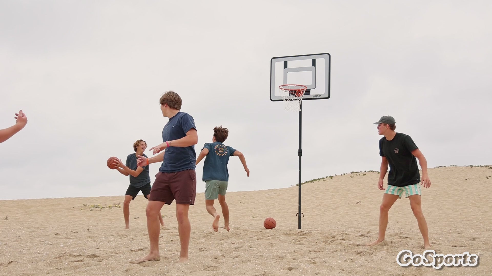 People playing basketball on the beach