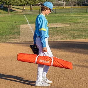 a young boy is walking on a baseball field
