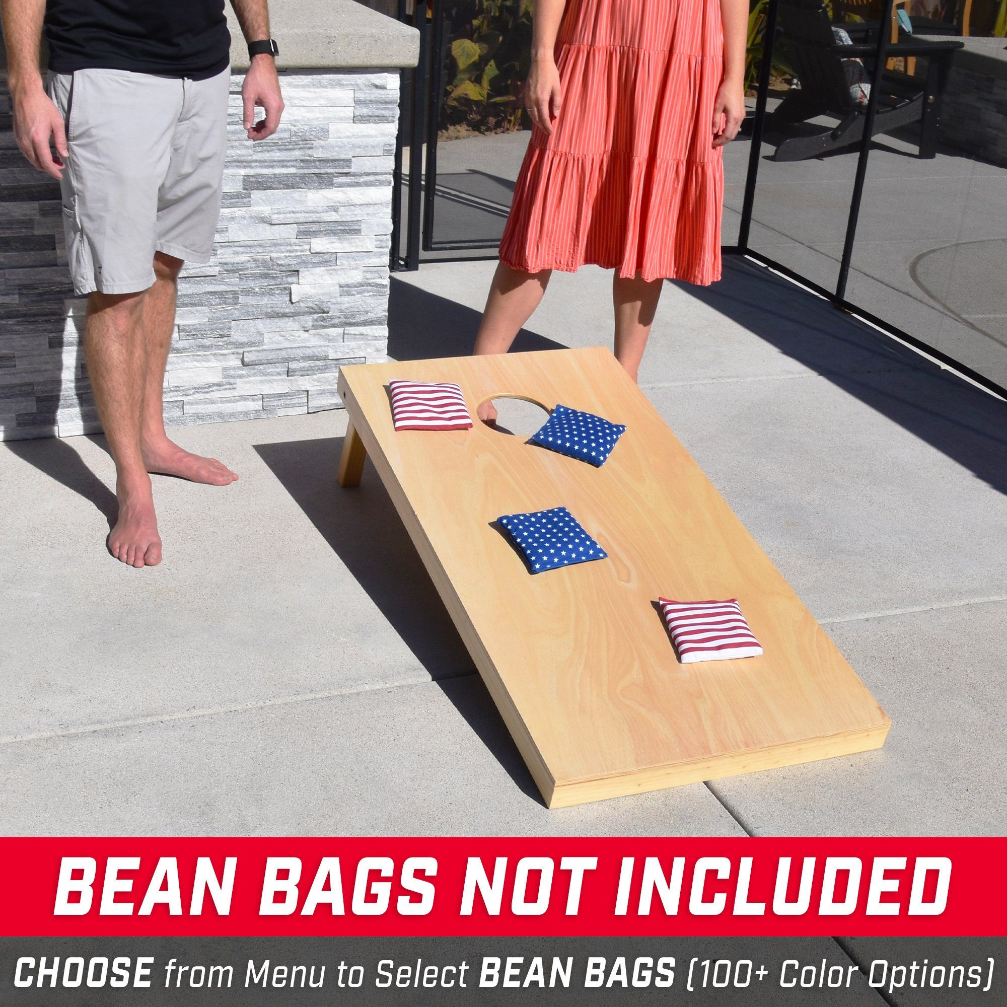 a man and woman standing next to a cornhole