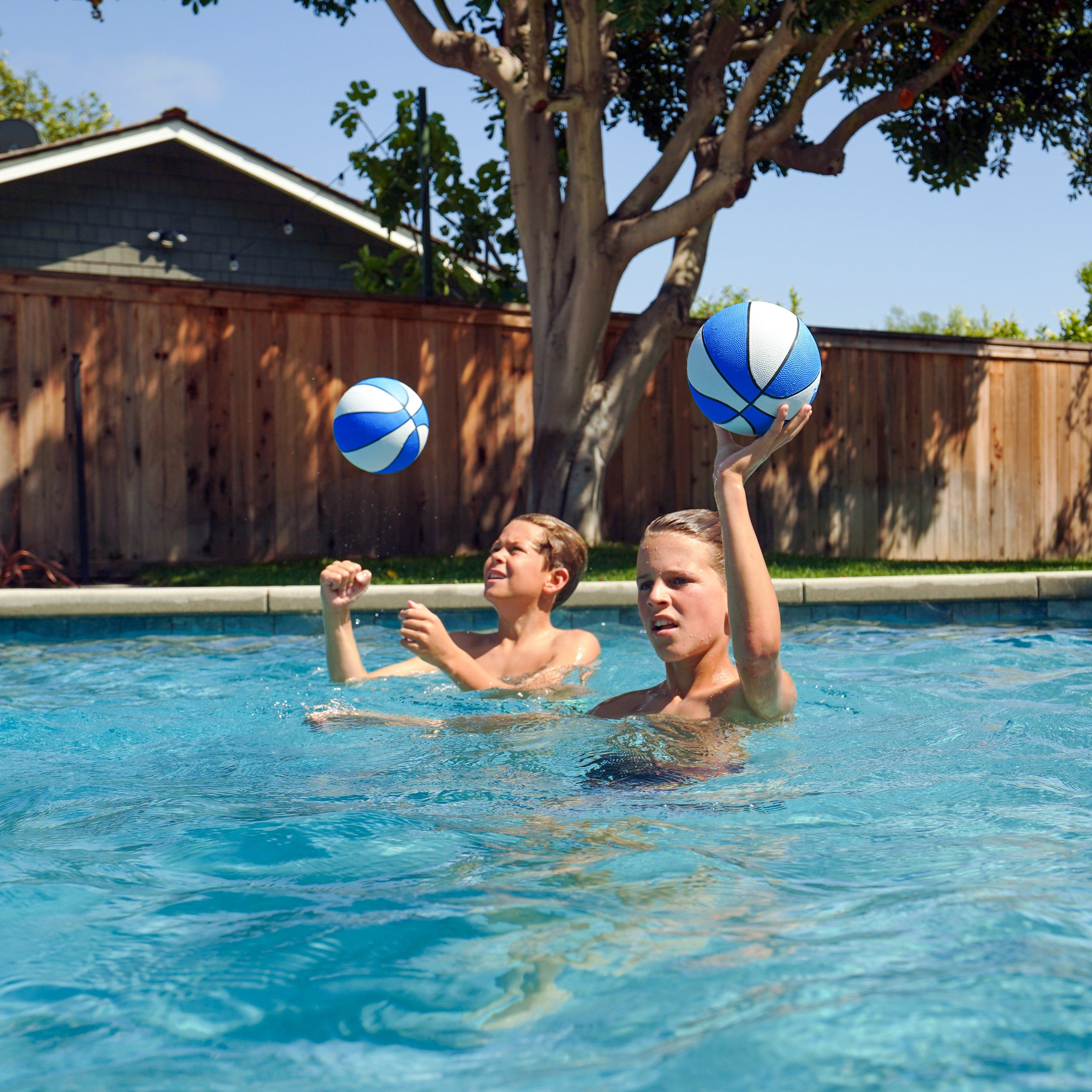 a boy playing with a ball in a pool