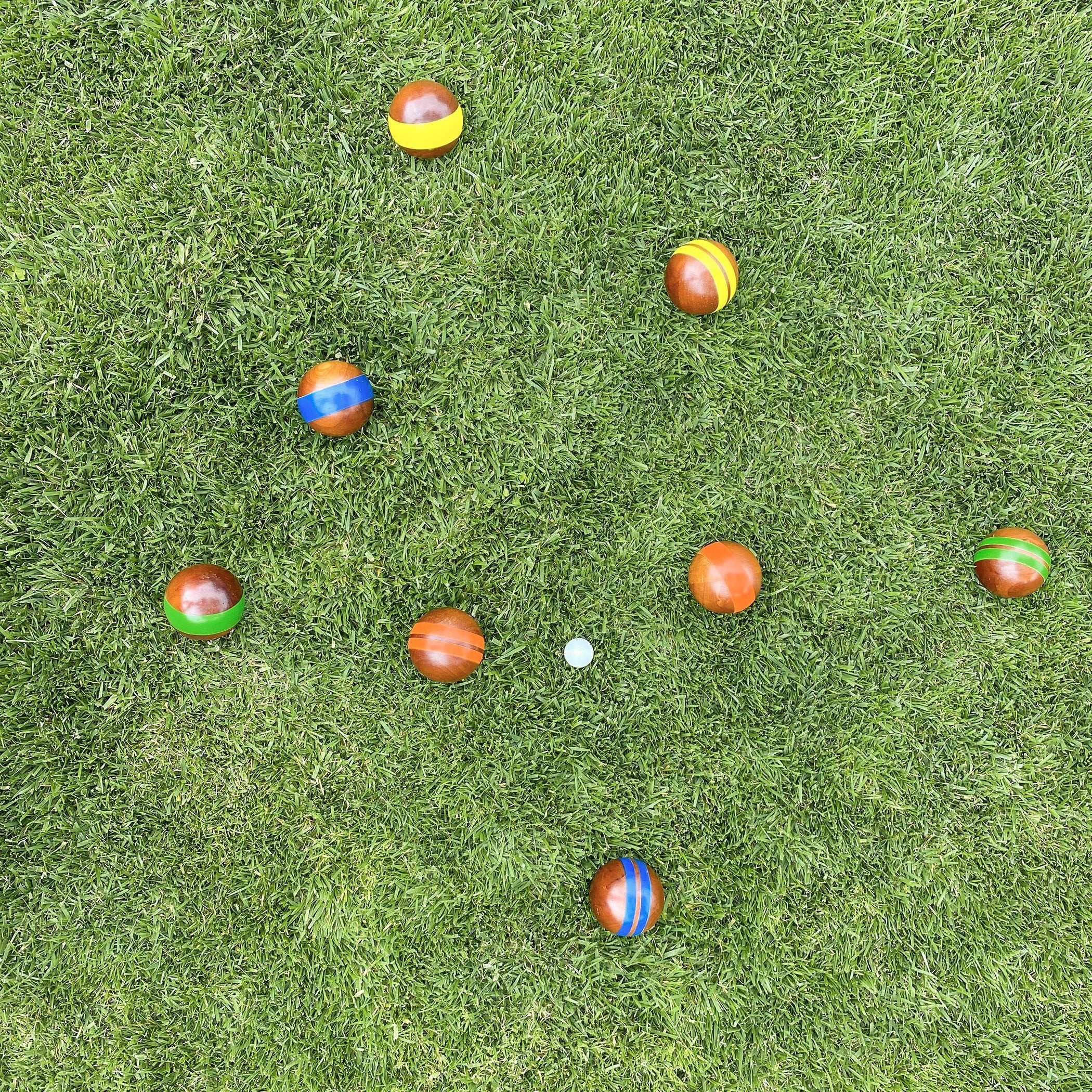 a group of colorful balls on a green grass