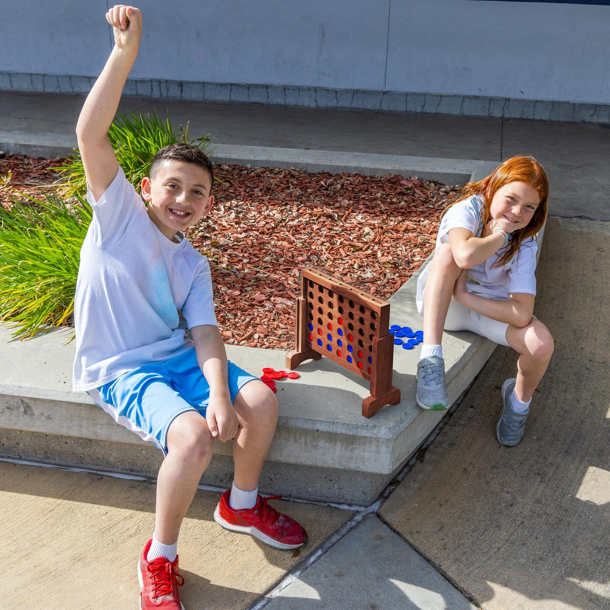 two young girls sitting on a cement bench