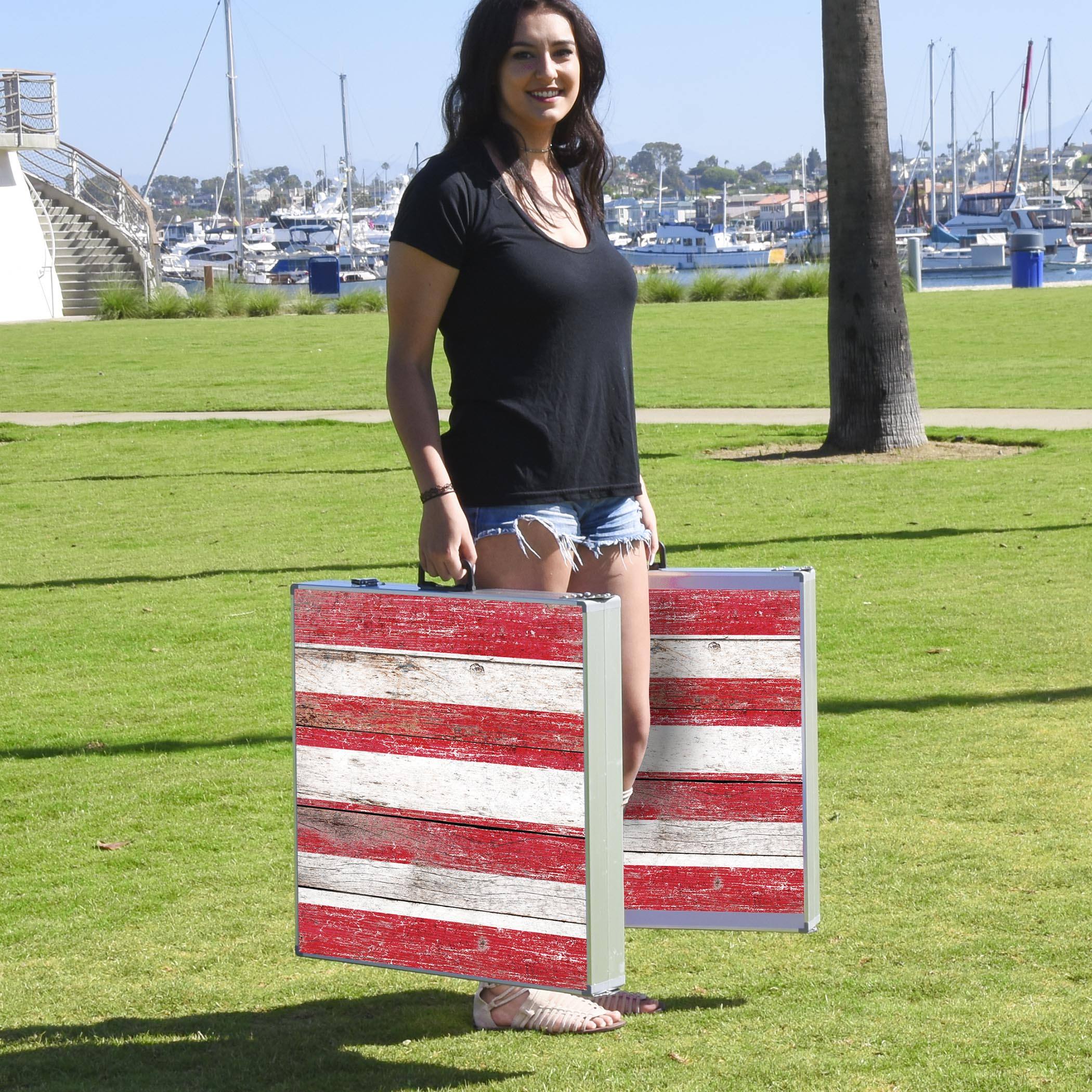 a woman standing in a field with a large american flag