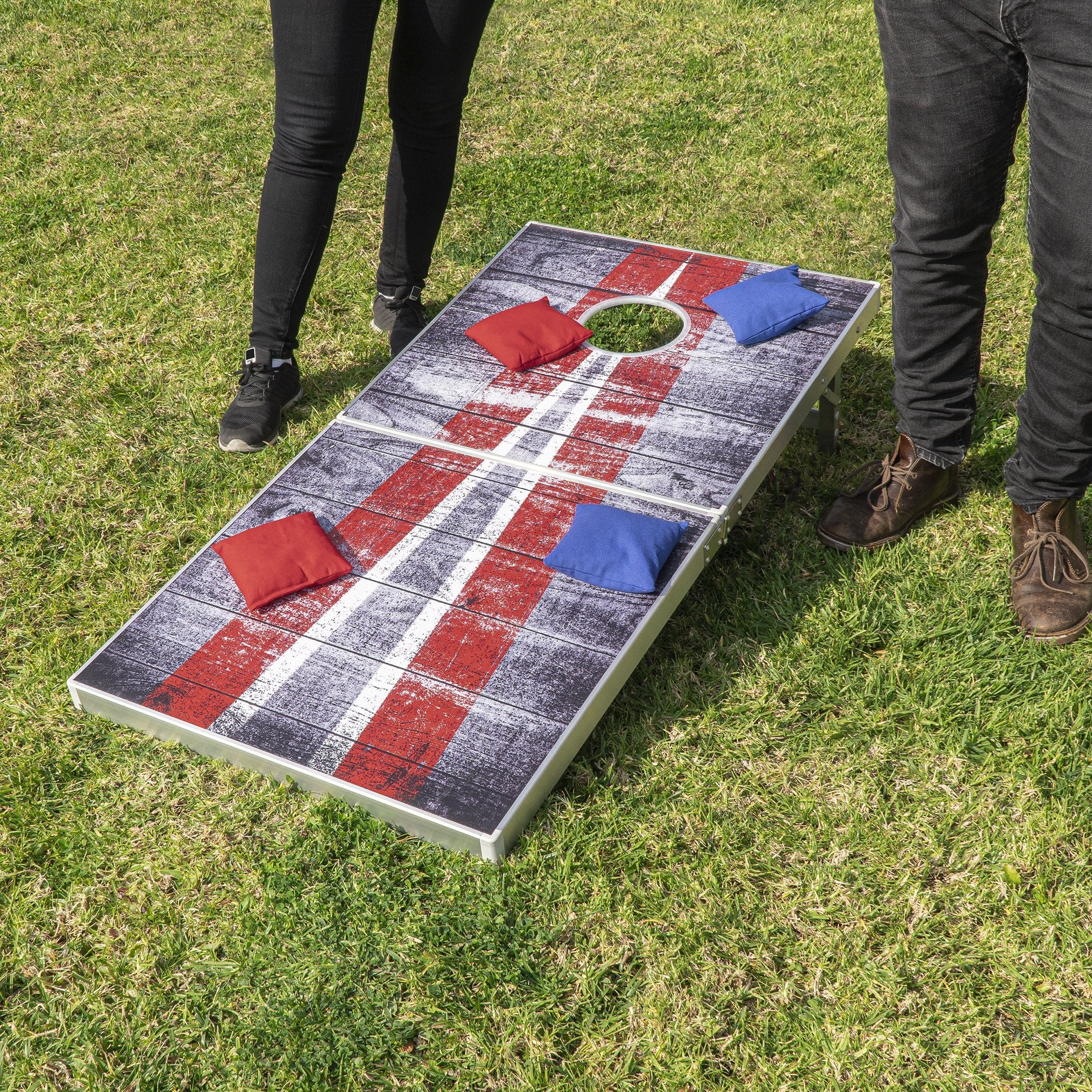 a man and woman standing next to a giant bean bag toss