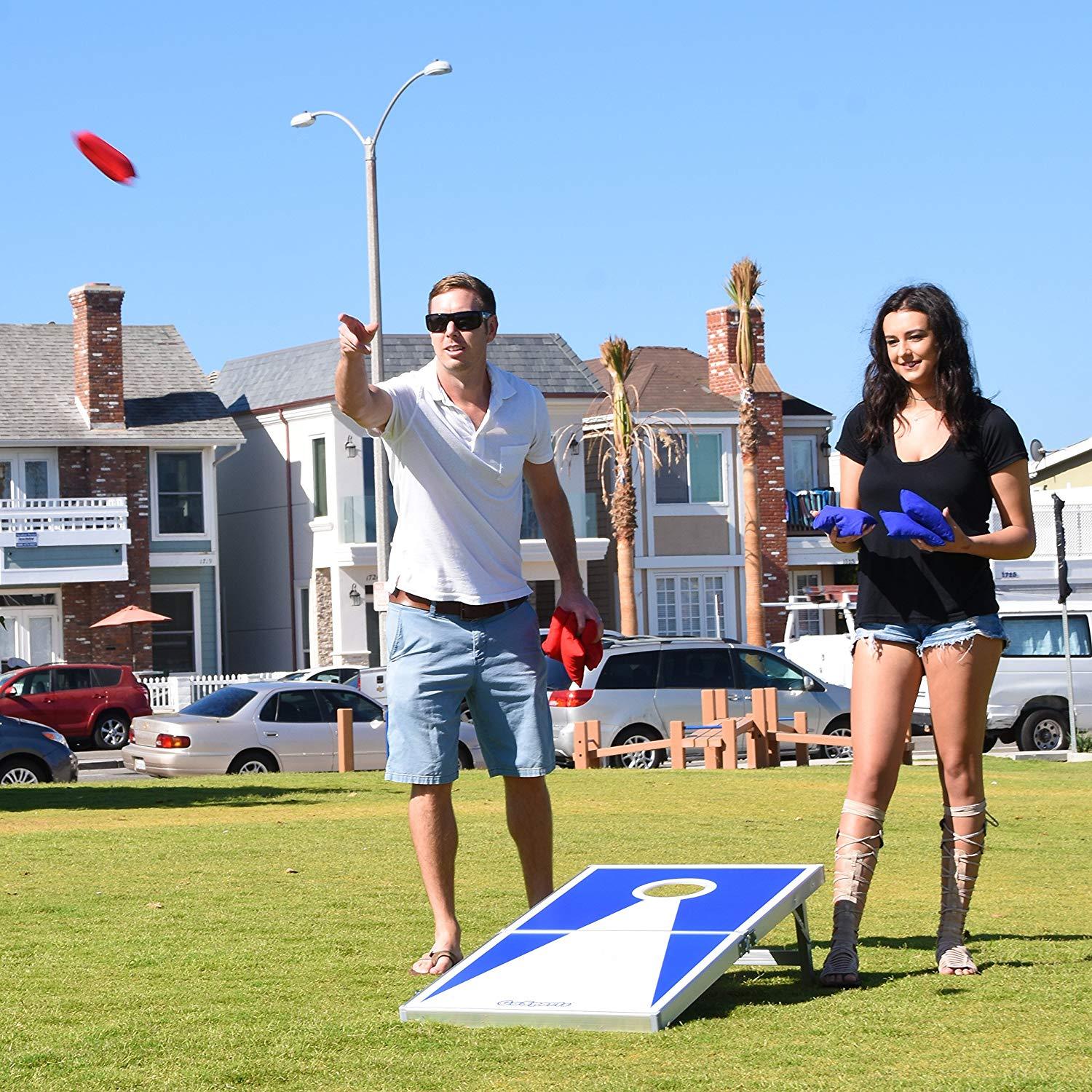 a man and woman playing corno game in a park