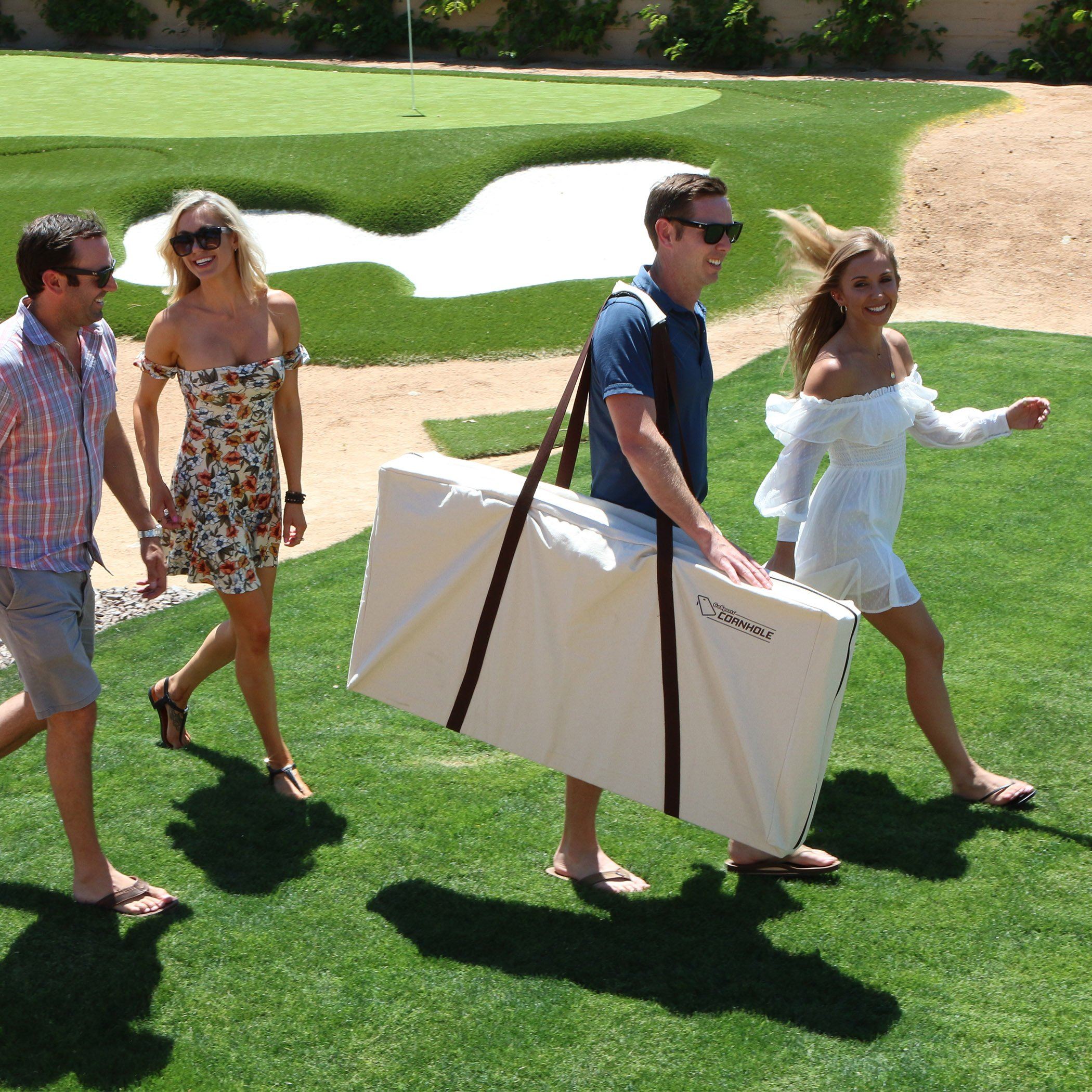 a group of people walking across a lush green field