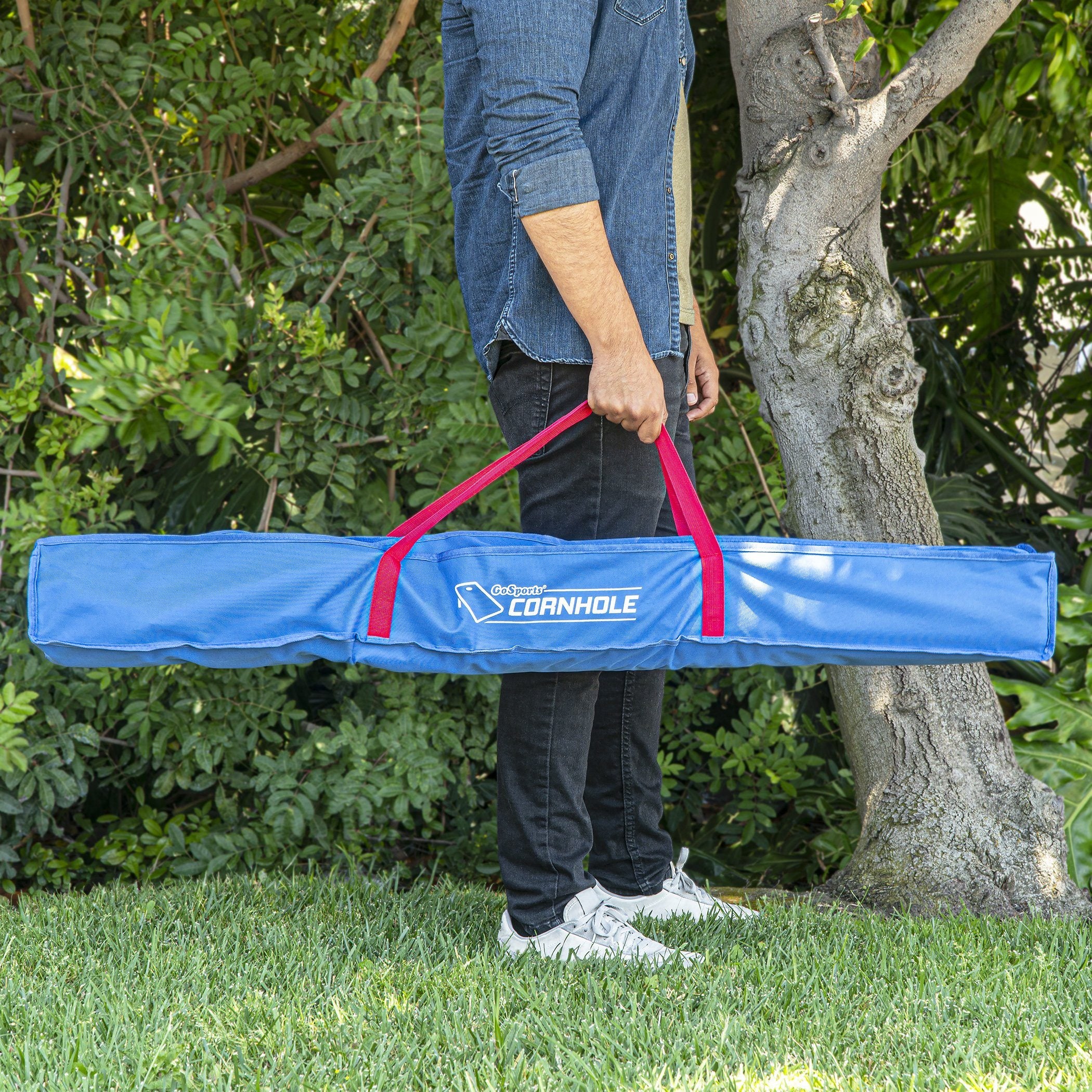 a man holding a blue bag in the grass