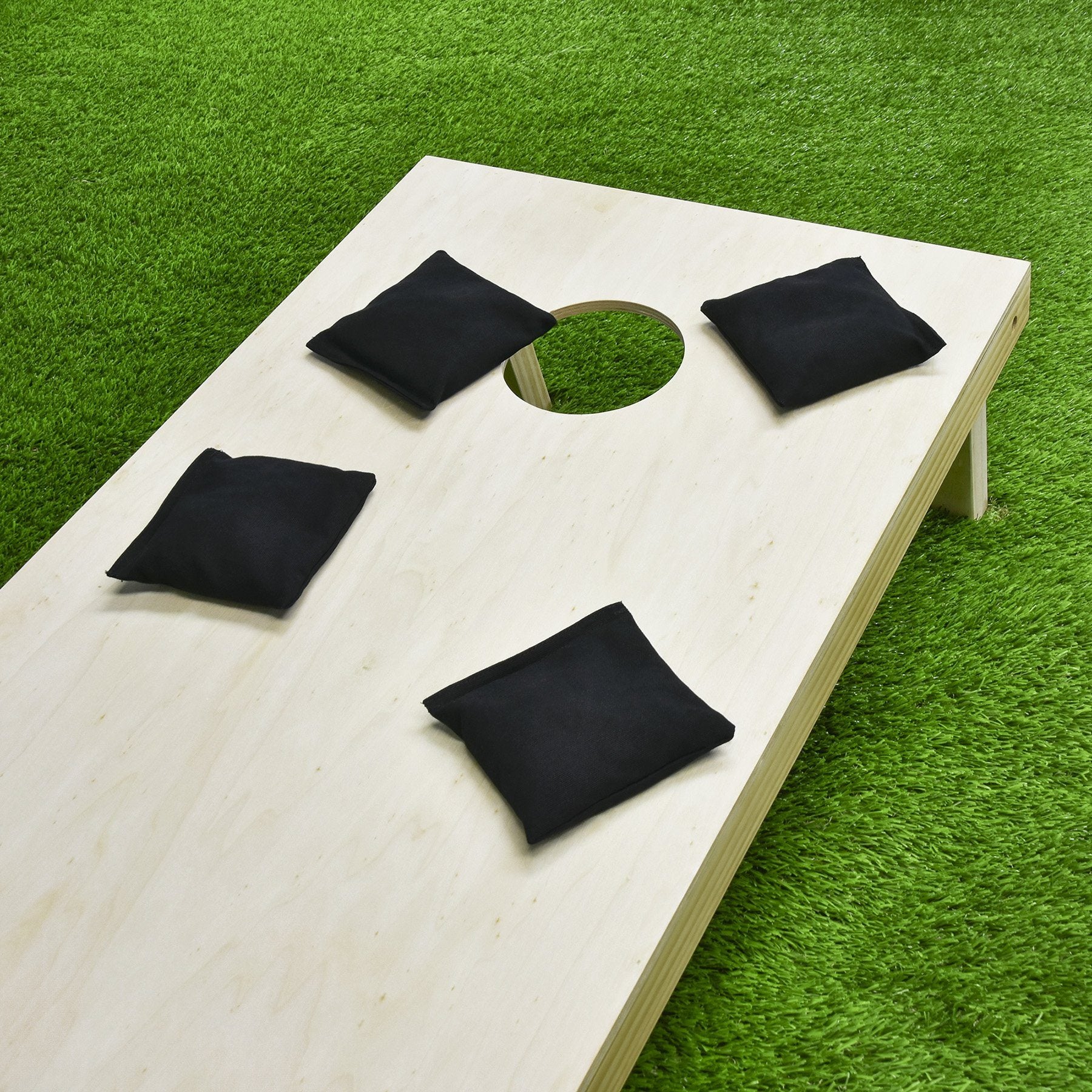 a wooden cornhole with black felt on it