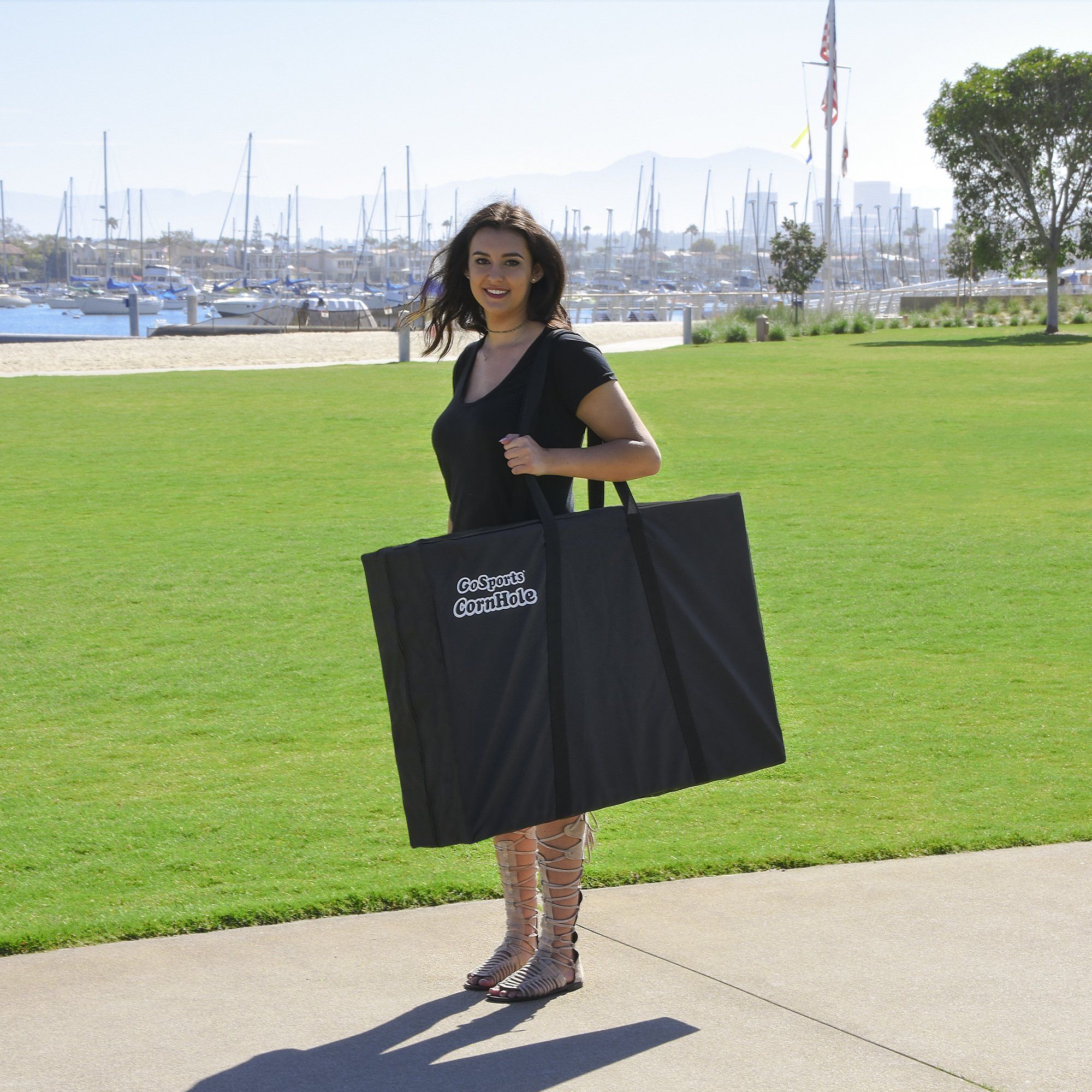 a woman holding a black bag in a park
