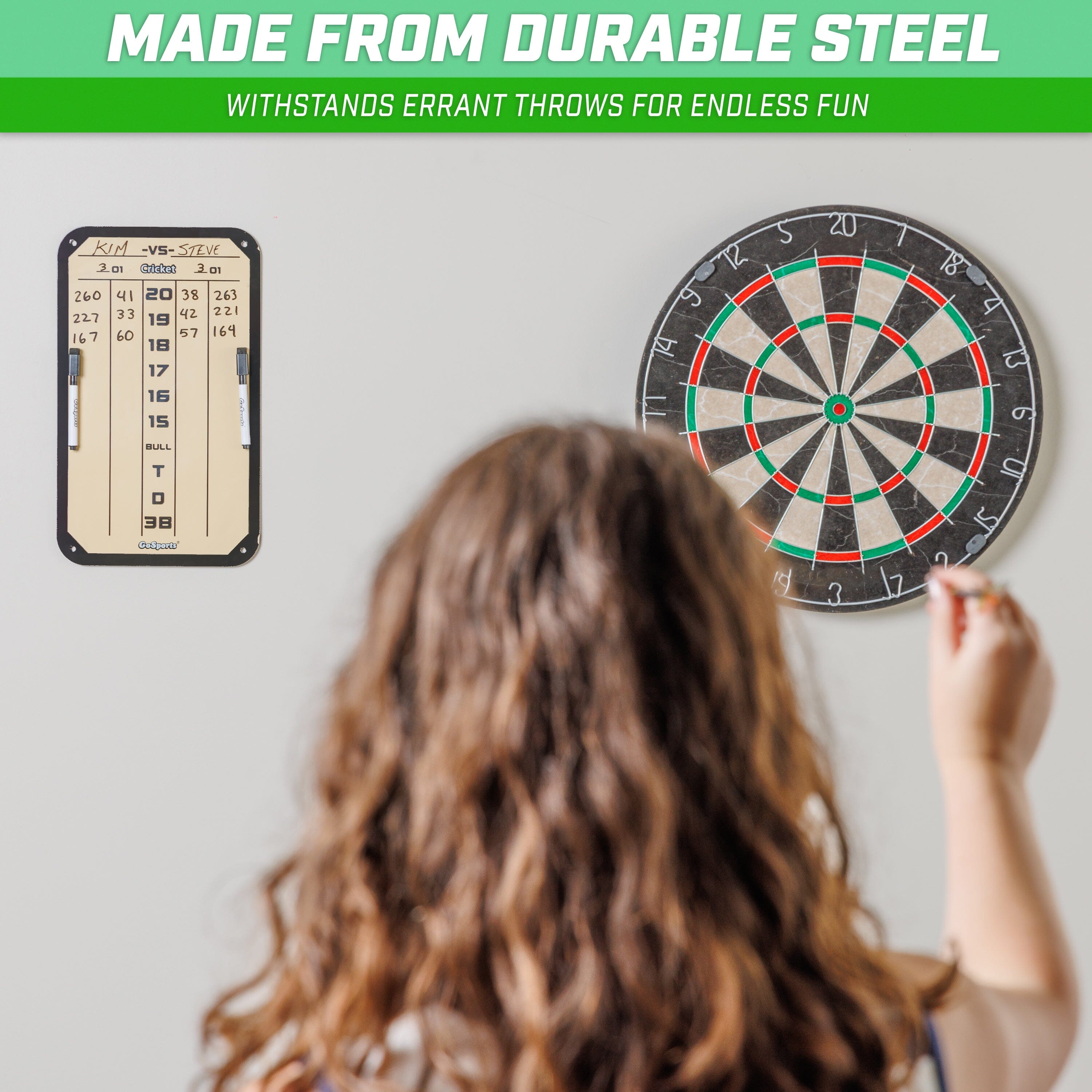 a girl is pointing at a dart board