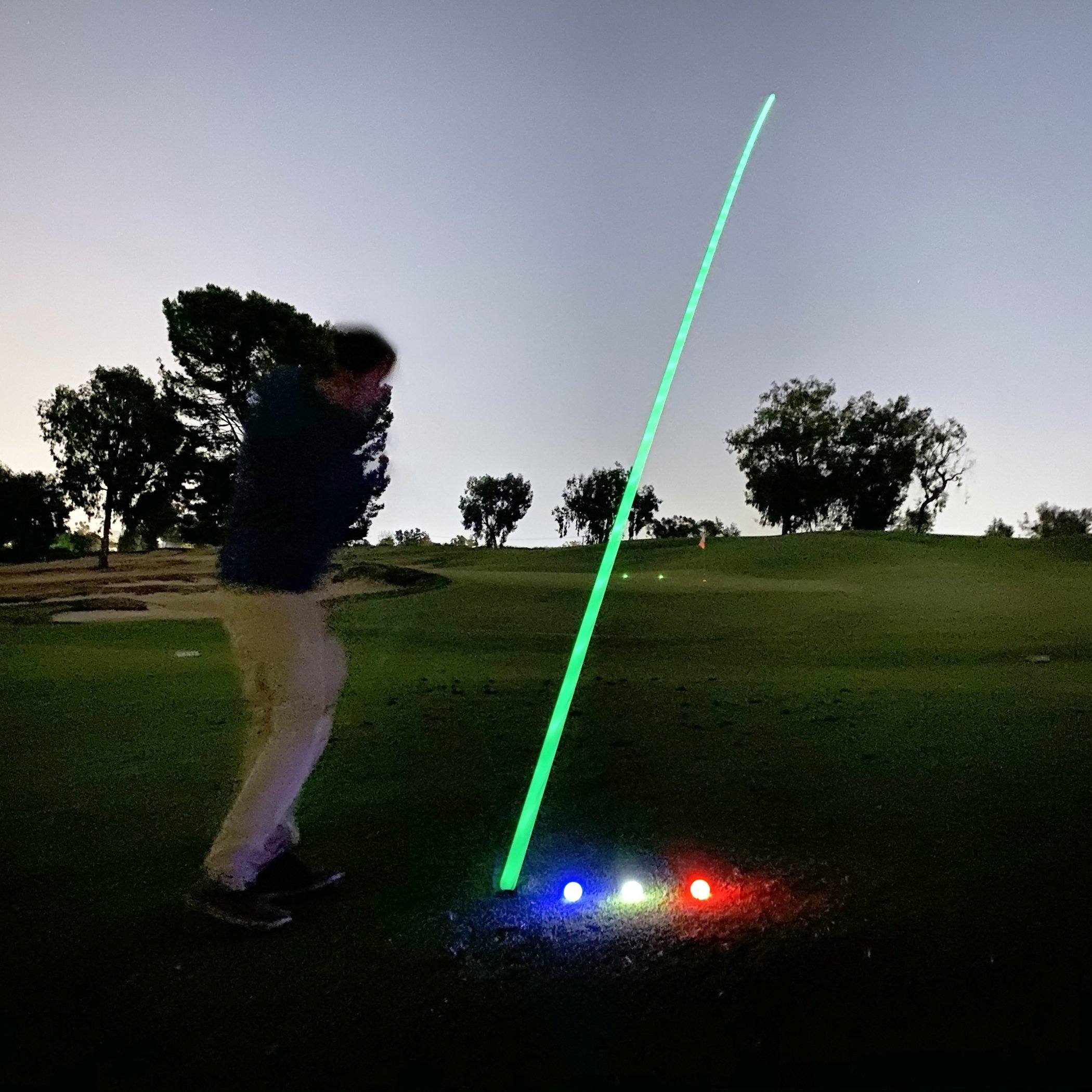 a man is hitting a ball with a green light