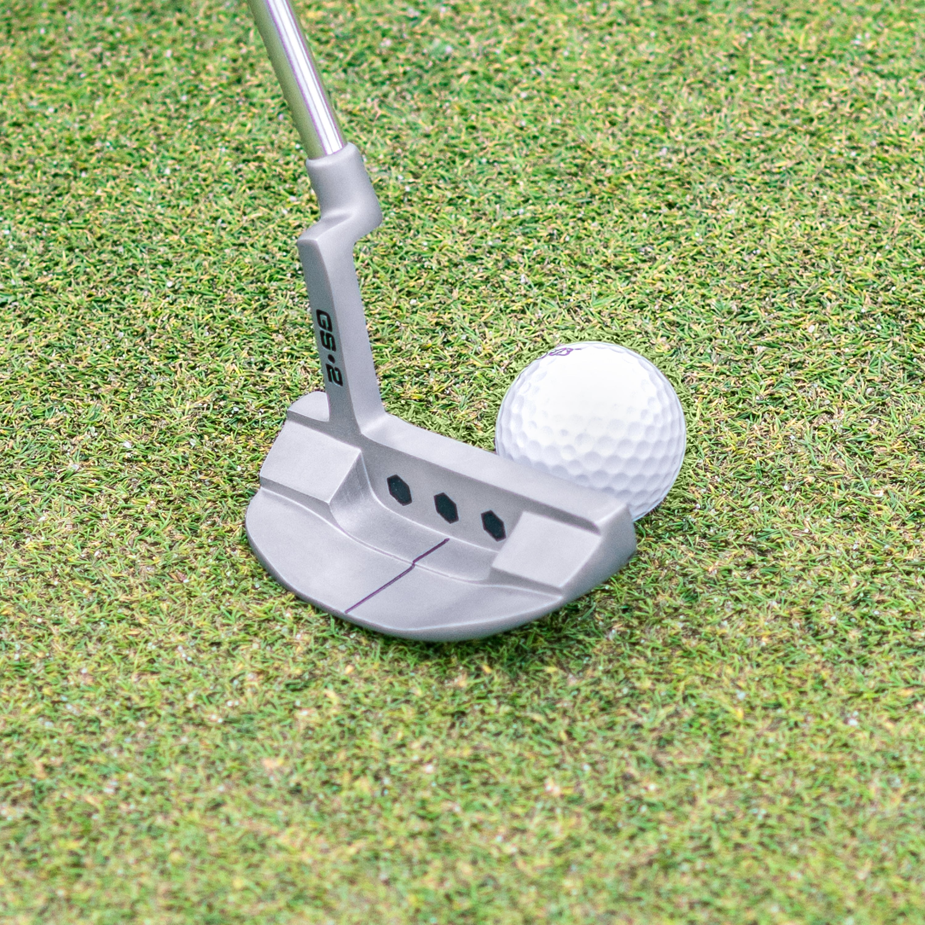a golf ball on the green with a putter