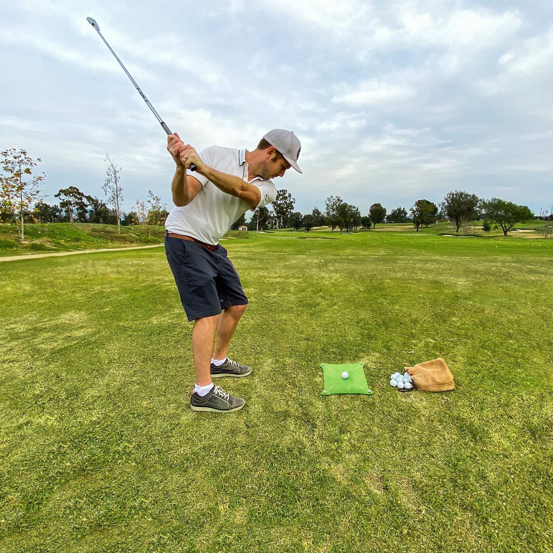 a man swinging a golf club on a golf course