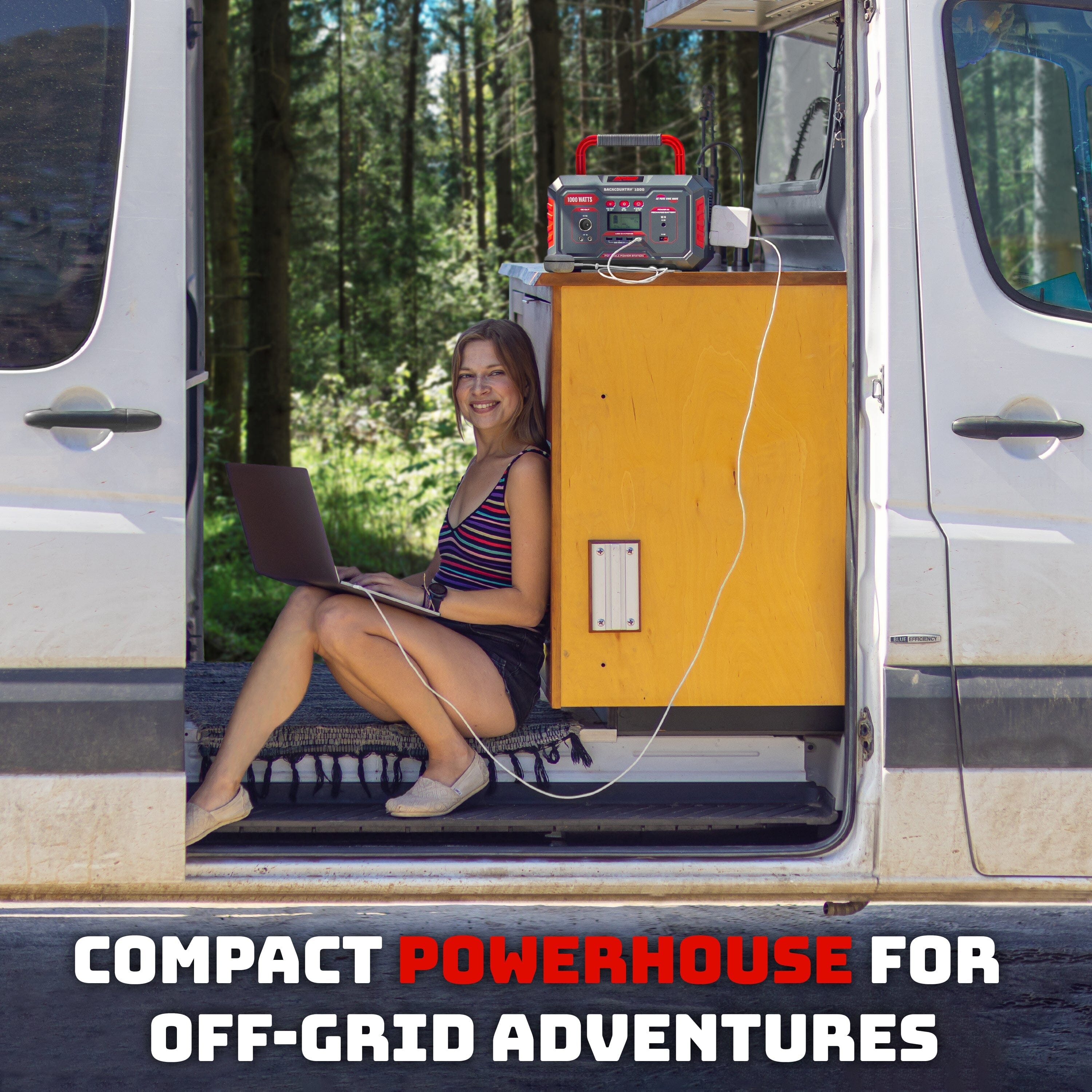 a woman sitting in the back of a van with a laptop