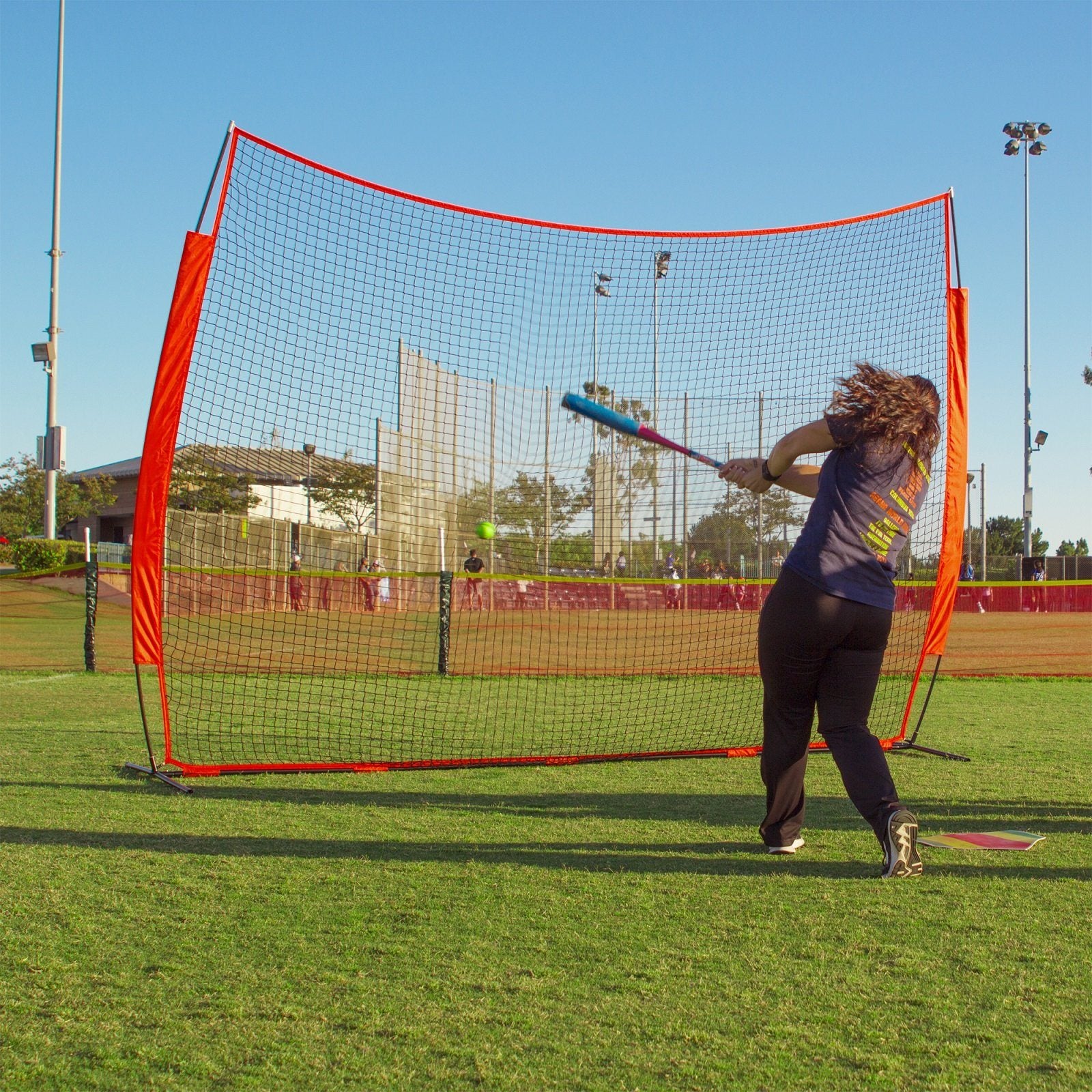 a woman is hitting a ball with a bat
