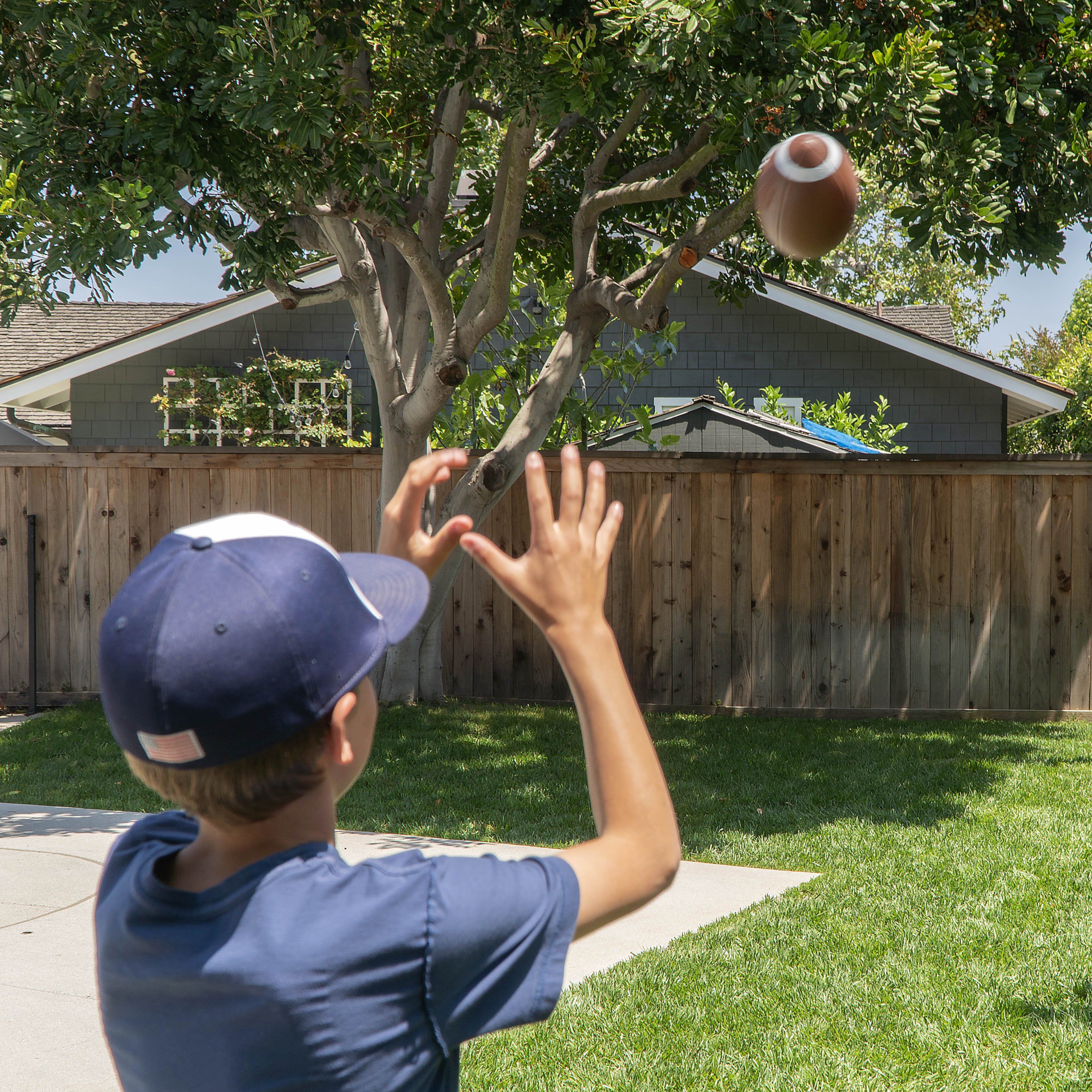 a boy in a baseball uniform throwing a ball