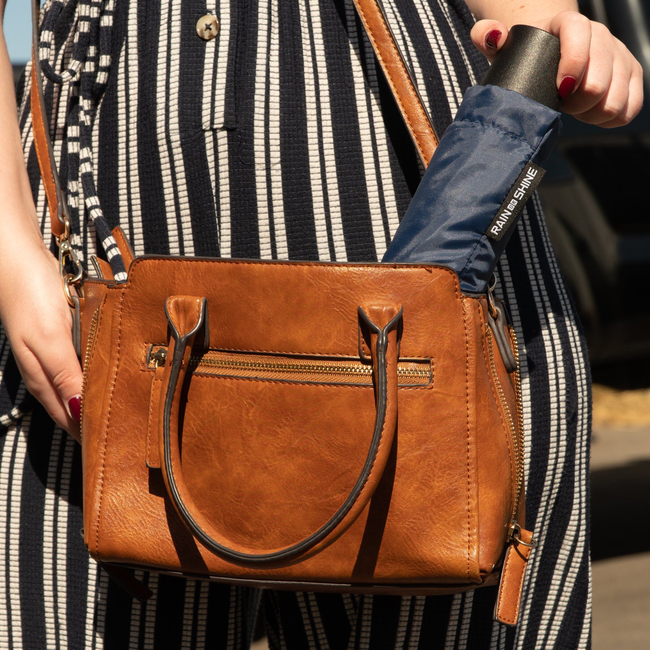 a woman holding a brown purse bag
