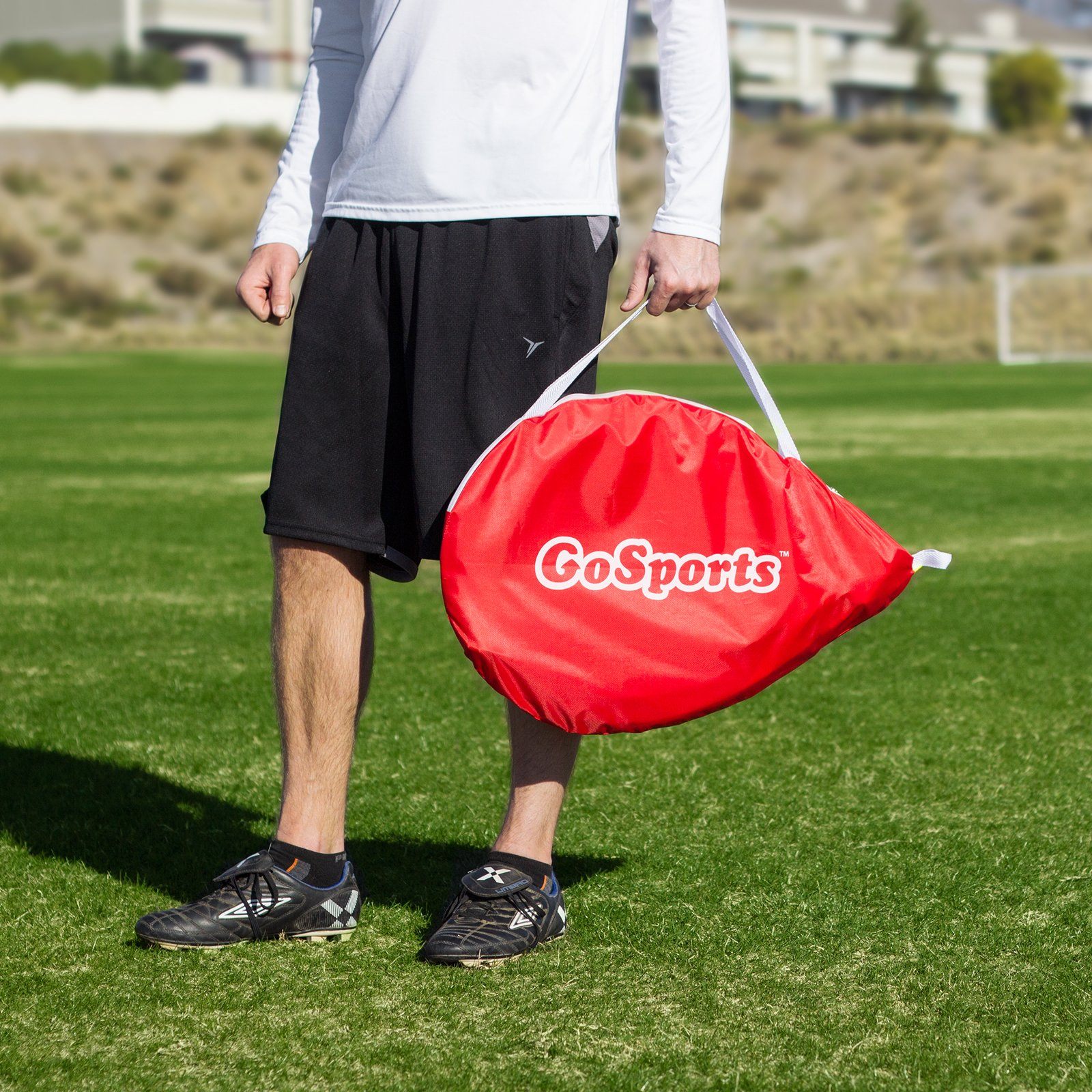 a man holding a red bag in a field