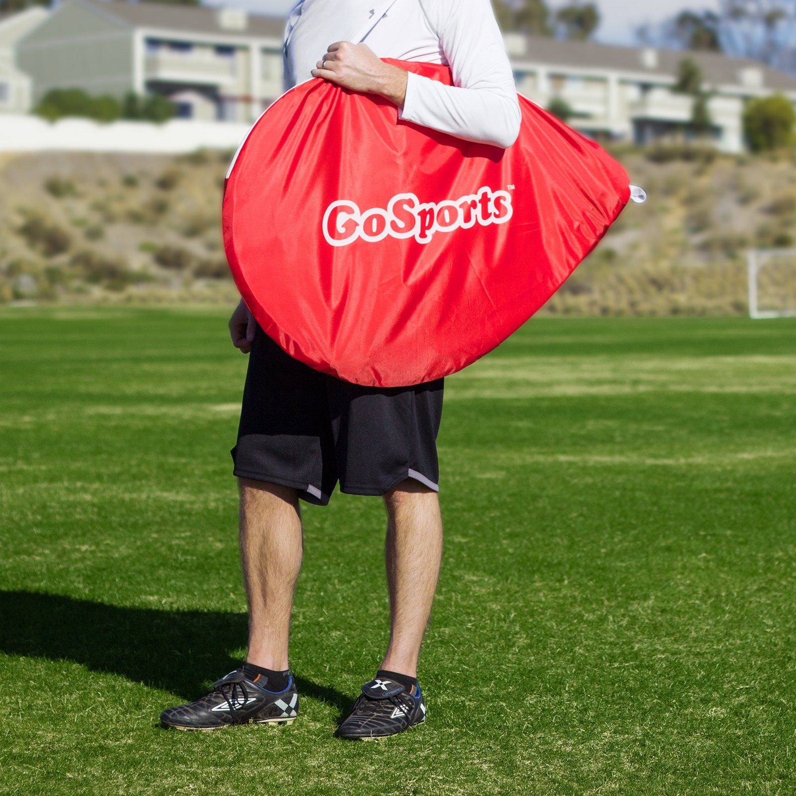 a man holding a red bag on a field