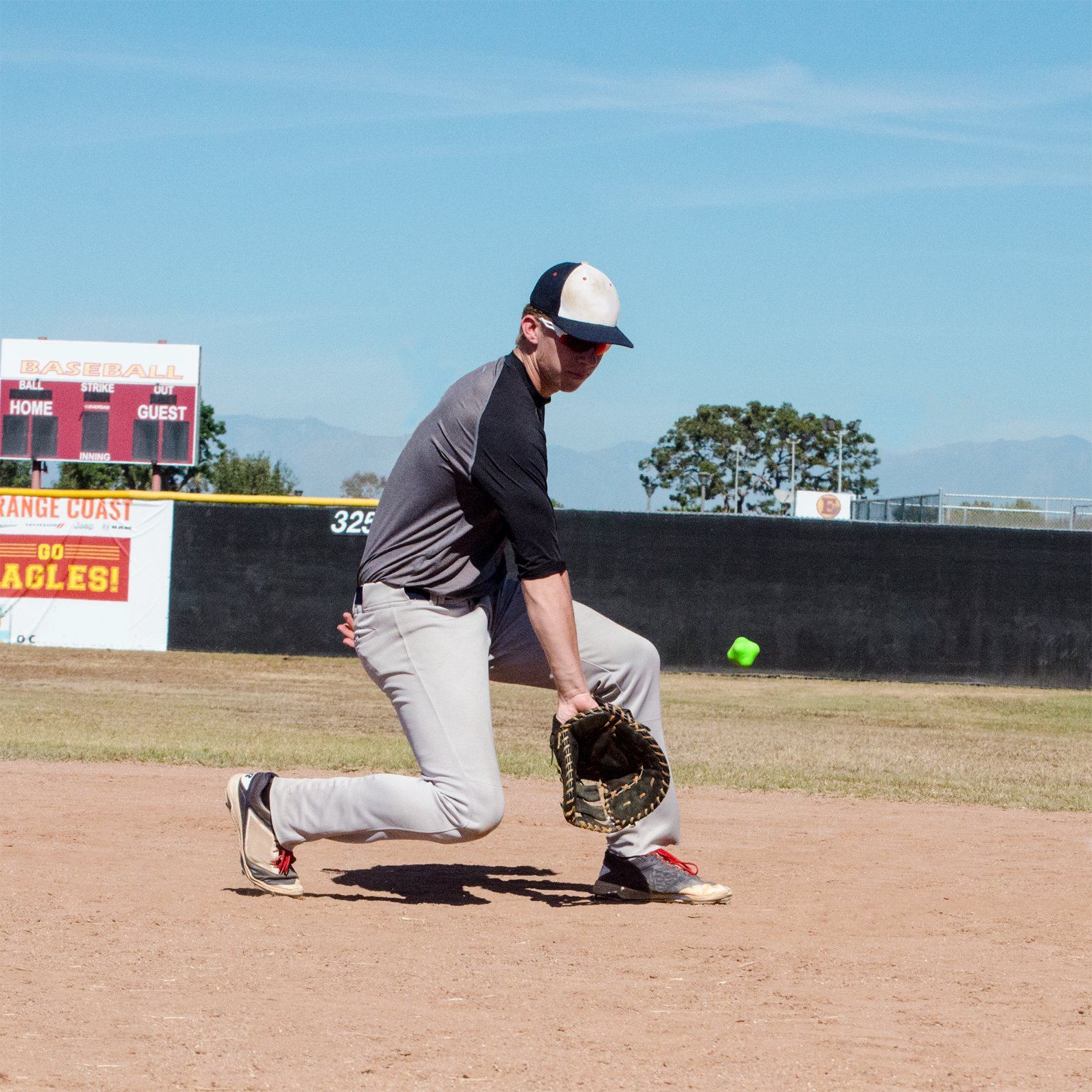 a man in a baseball uniform is running to catch a ball