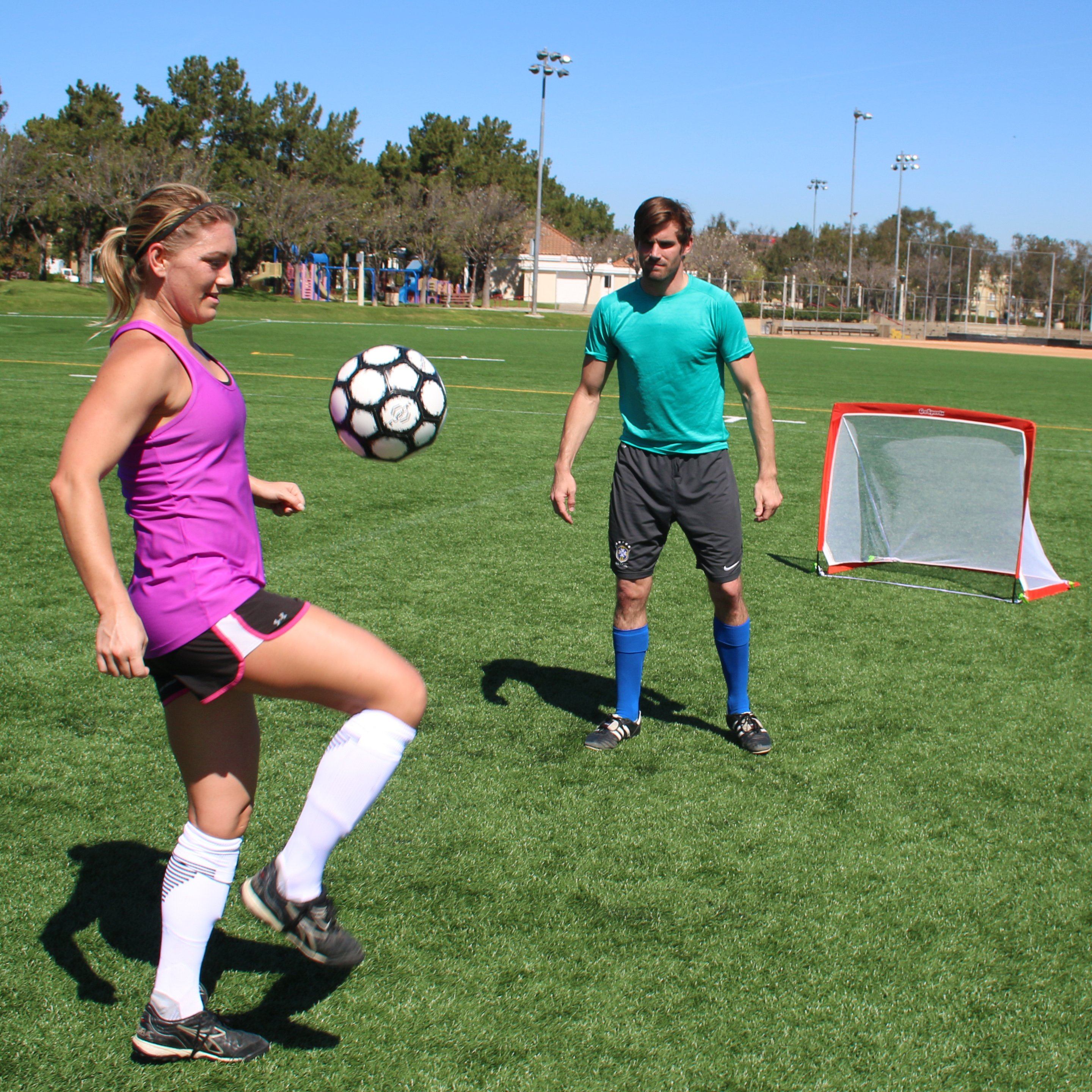 a woman kicking a soccer ball on a field
