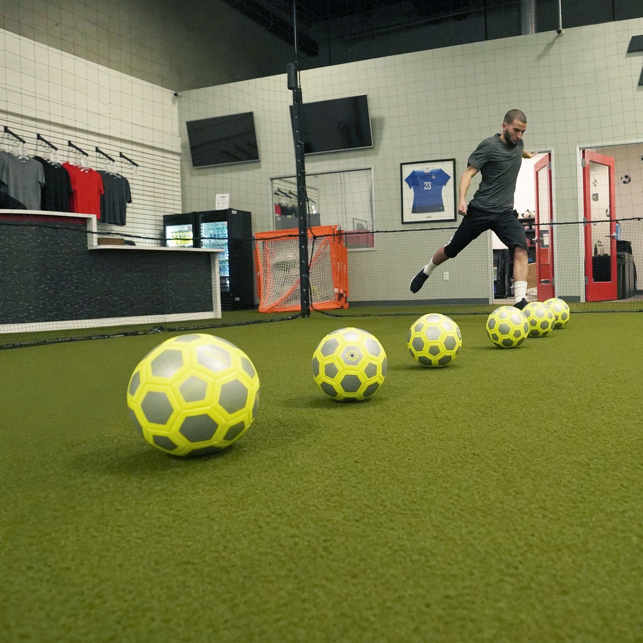 a man kicking a soccer ball on a soccer field