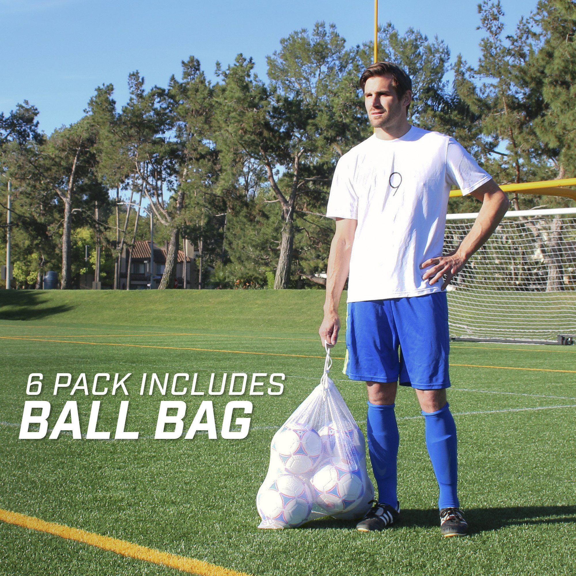 a man standing on a soccer field holding a bag