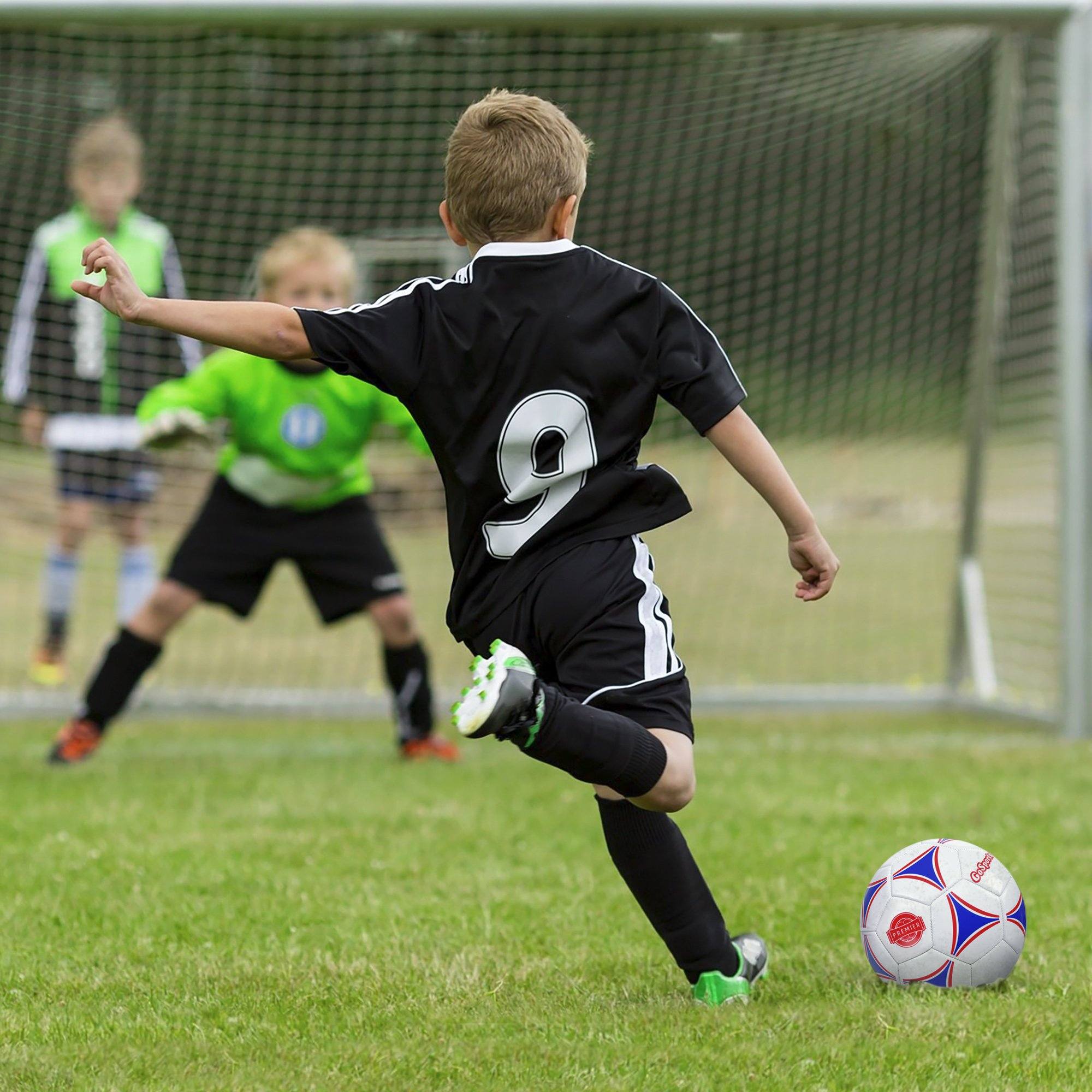 a boy kicking a soccer ball on a field