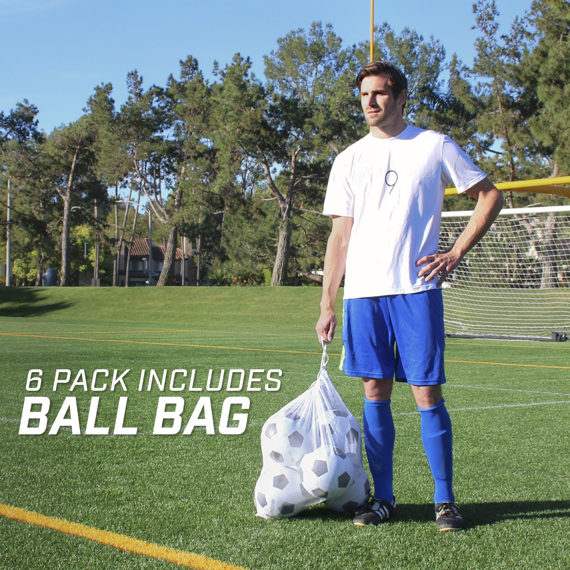 a man standing on a soccer field with a bag of balls