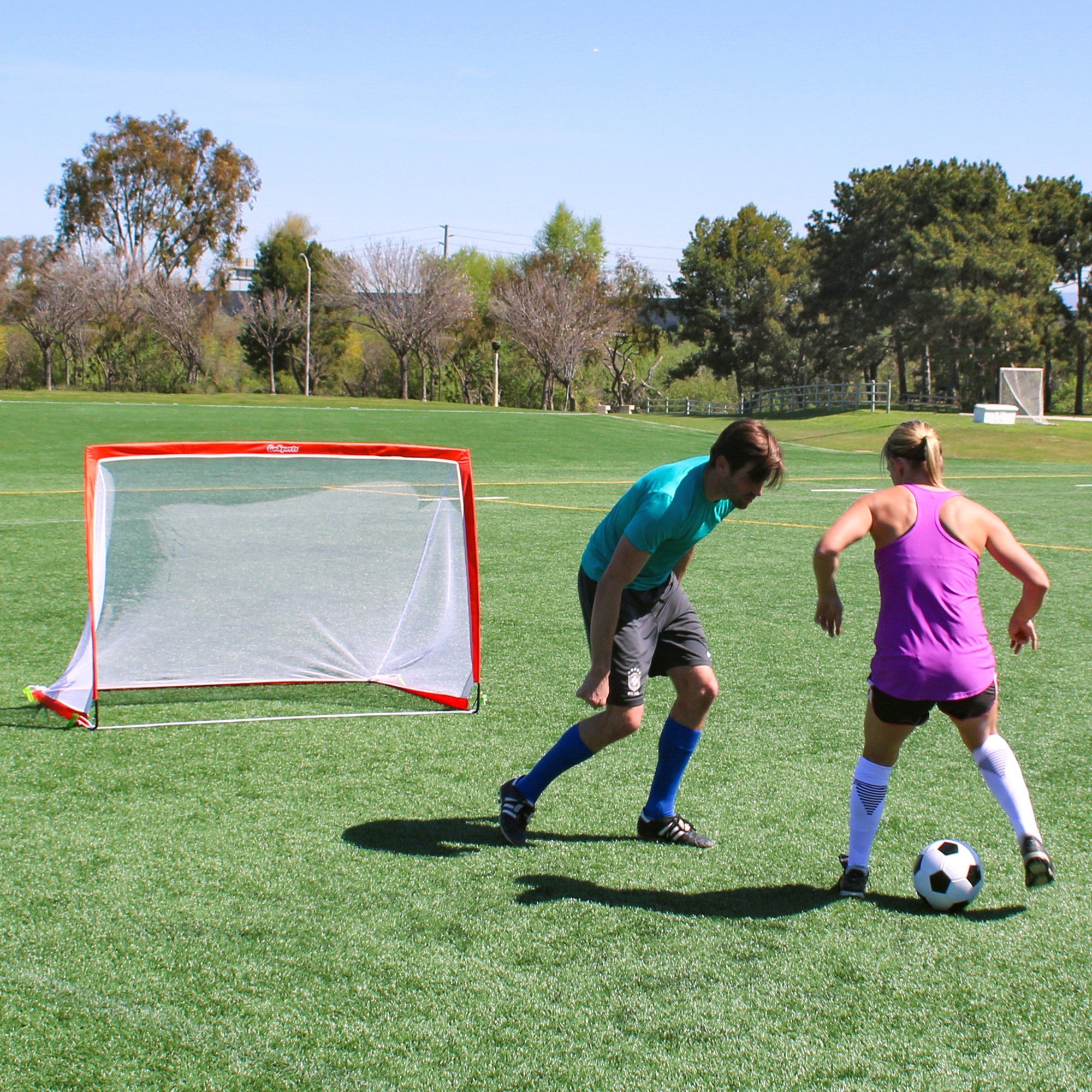 two girls playing soccer on a field