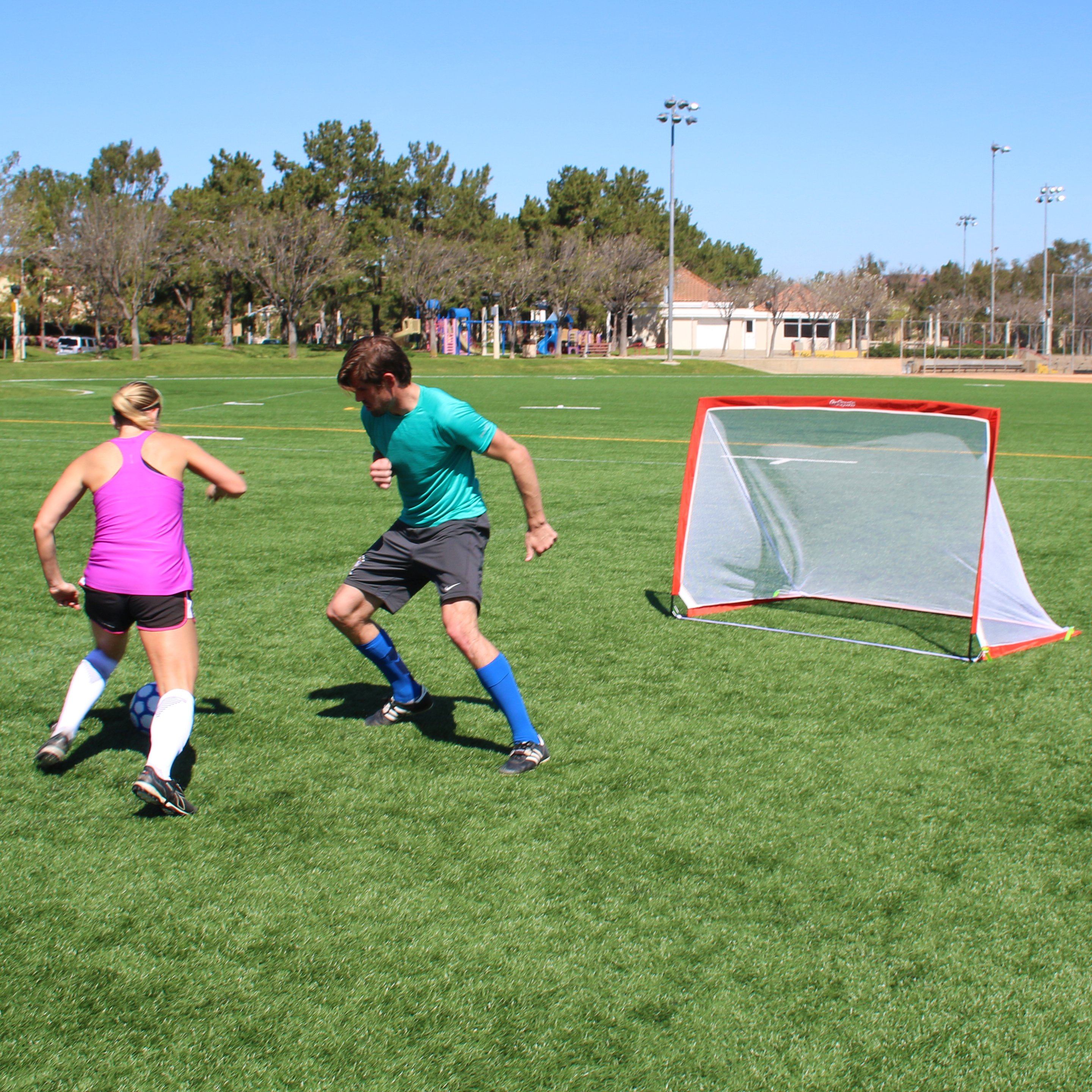 a man and woman playing soccer on a field