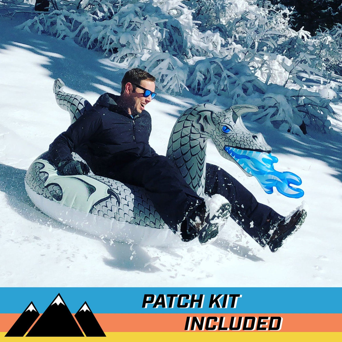 Man in sunglasses riding a GoSports Ice Dragon snow tube past snowy trees with a patch kit included banner