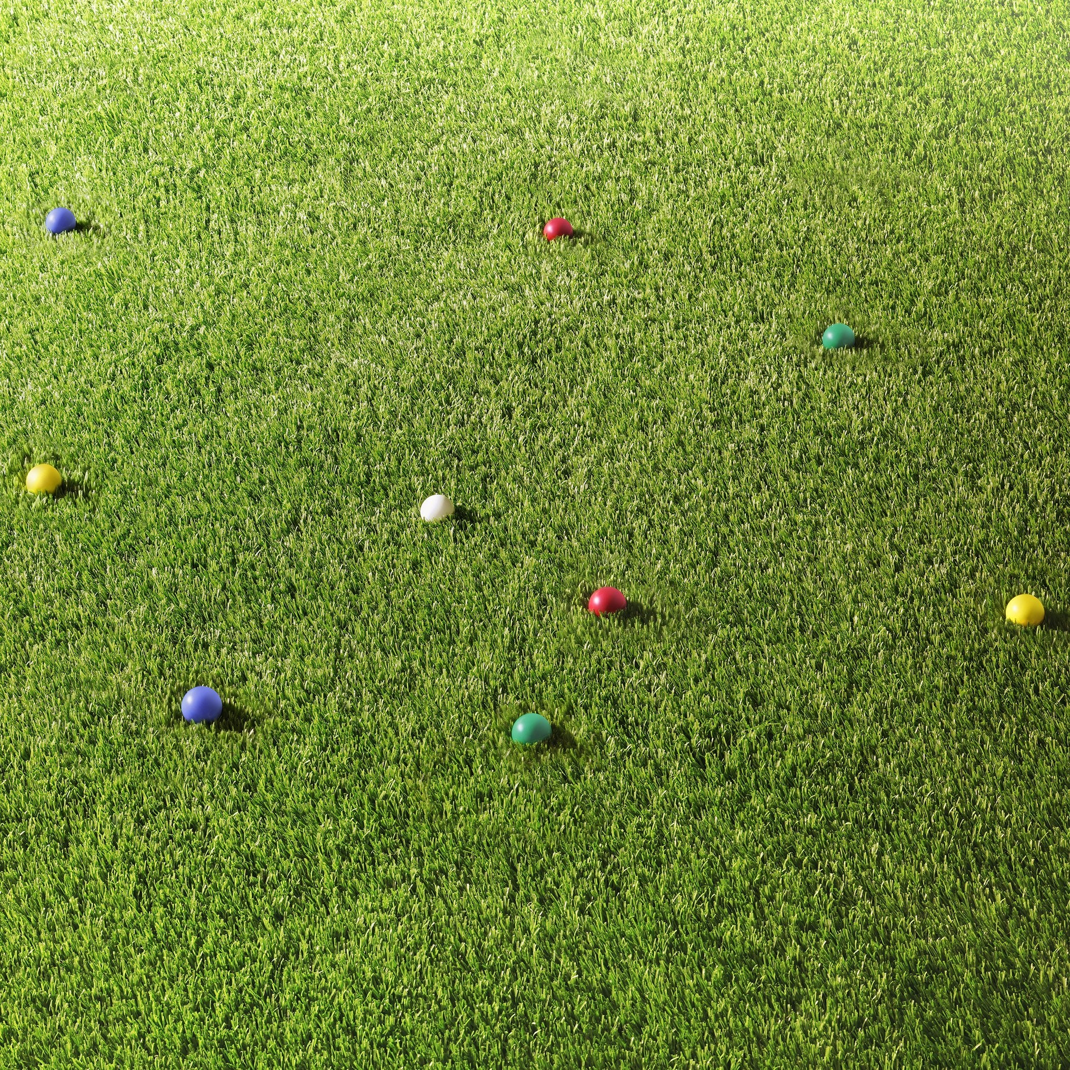 a group of colorful balls on a green lawn