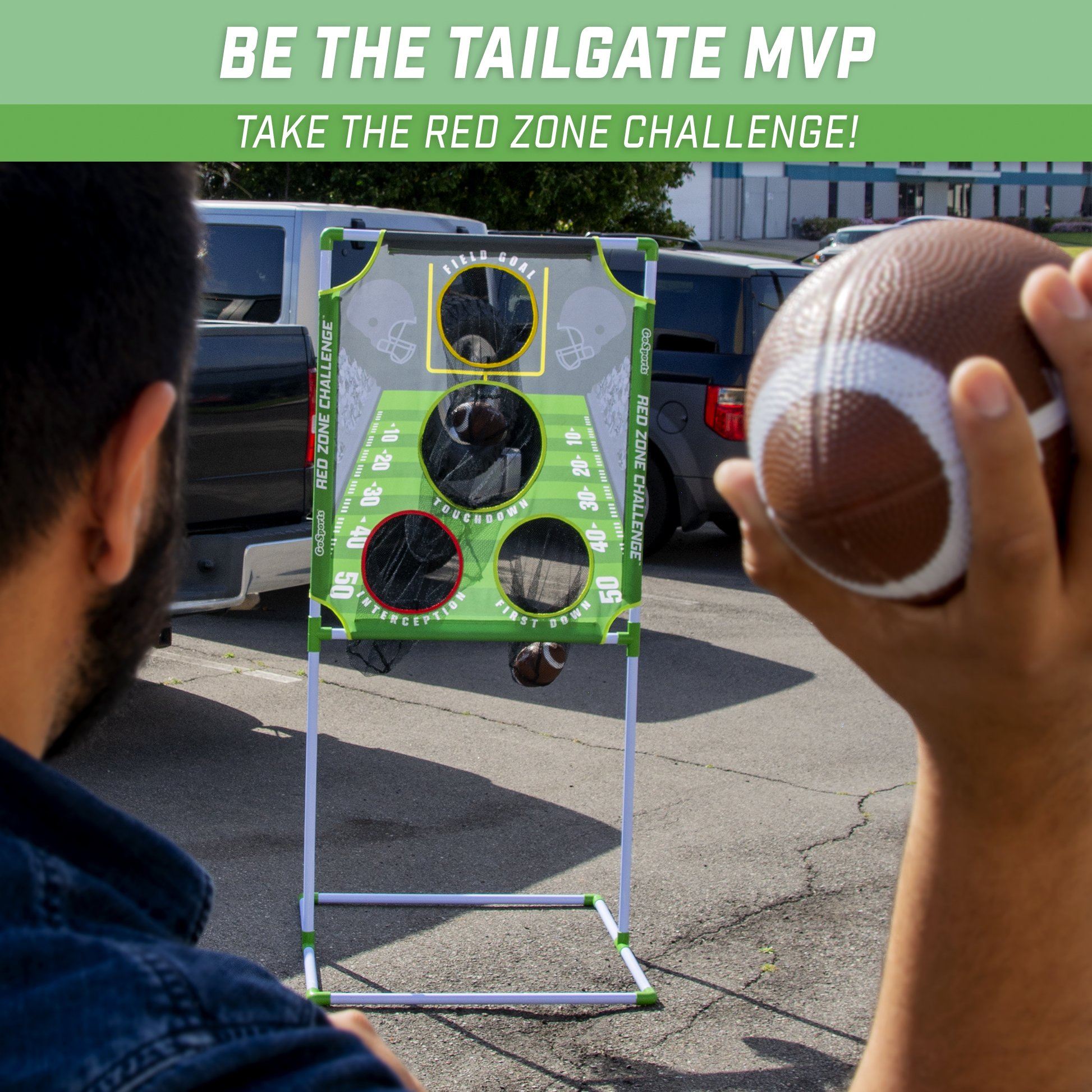 a man holding a football in front of a sign